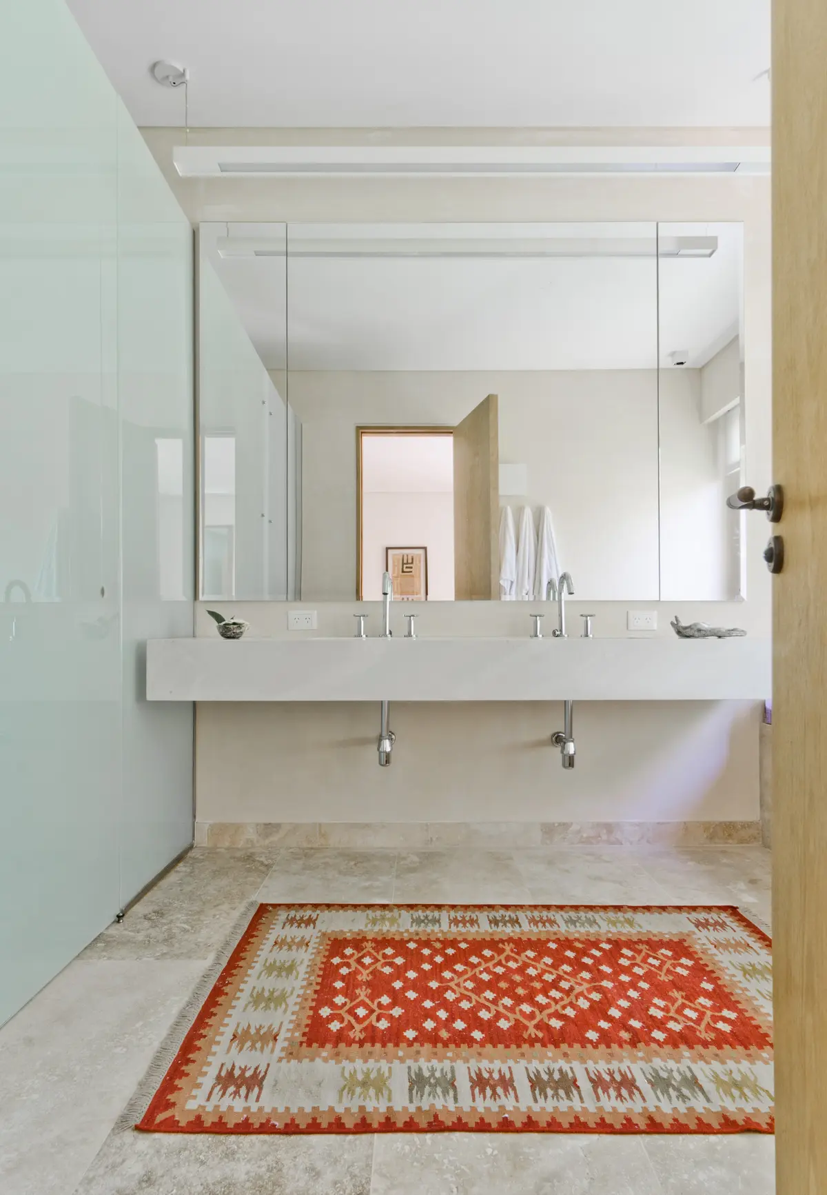 Baño moderno con doble bacha integrada y alfombra geométrica — proyecto Casa P, por Estudio Dado, en San Isidro