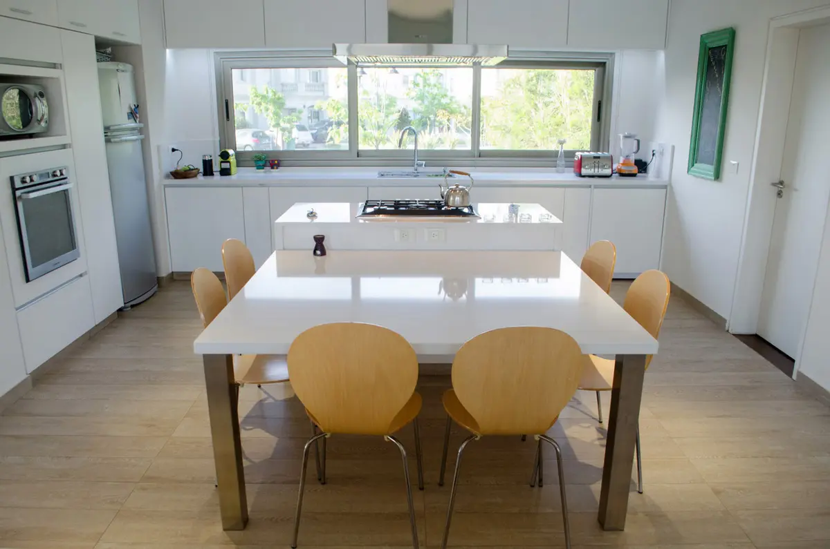 Cozinha moderna com ilha, mesa amarela e vista externa — projeto Casa Nordelta, por linearecta.arquitectura, em Nordelta