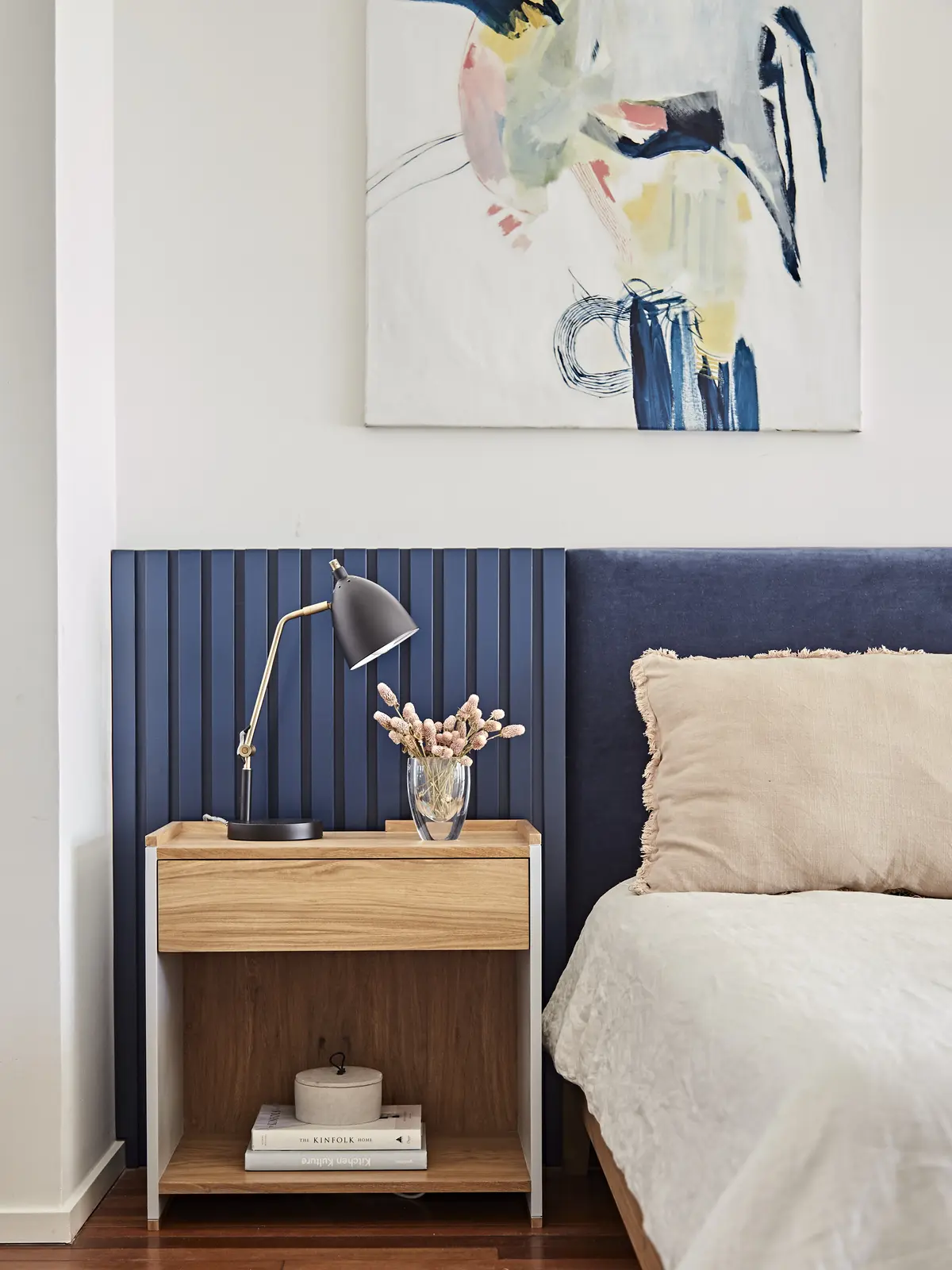 Dormitorio con panelado de madera azul, mesa de luz minimalista y cuadro abstracto — proyecto Proyecto Arboris, por URBANO estudio, en San Isidro