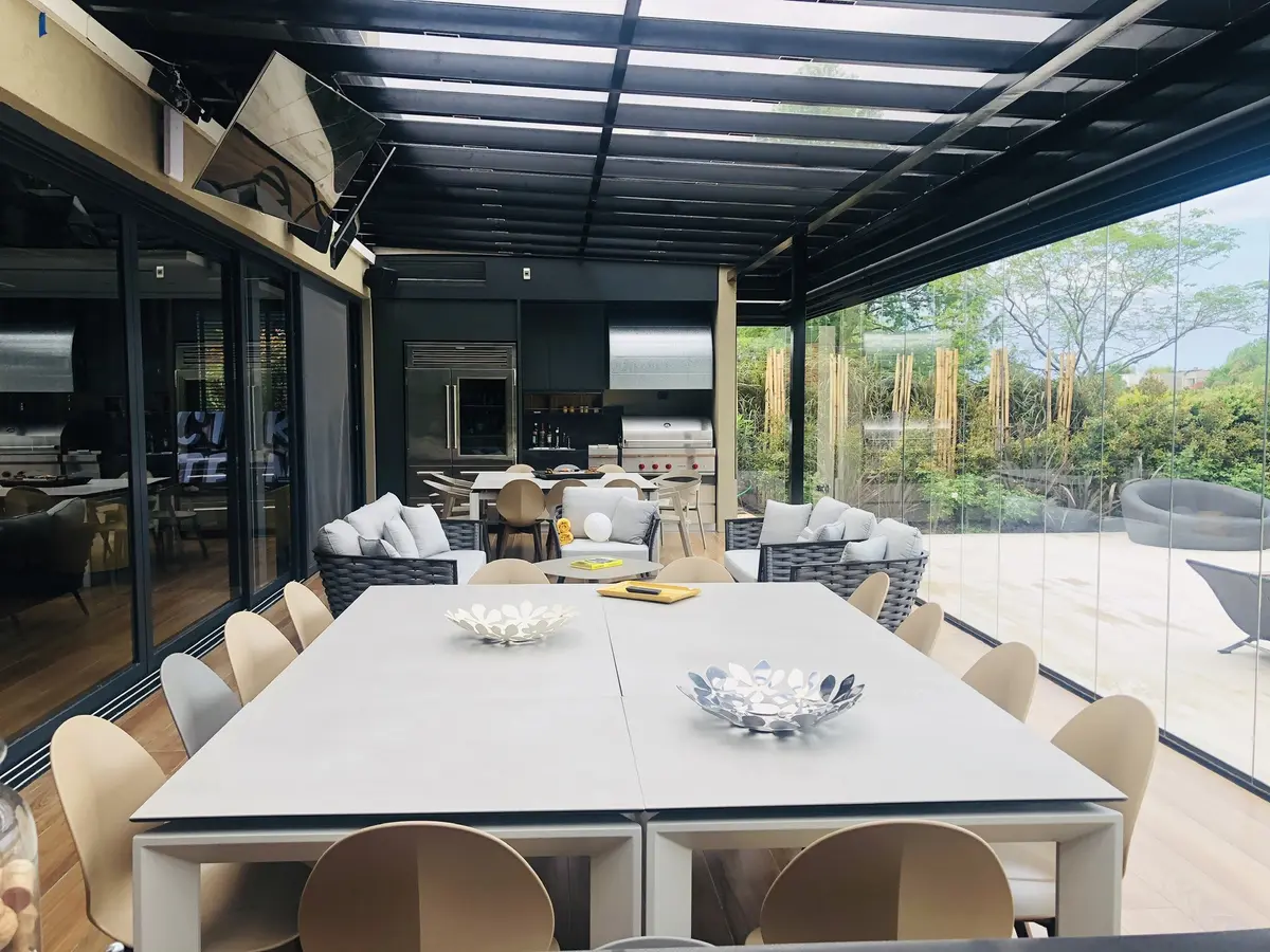 sala de jantar externa moderna com pérgola e portas de vidro — projeto SANTA BARBARA, por Greschek Obras, em Benavidez