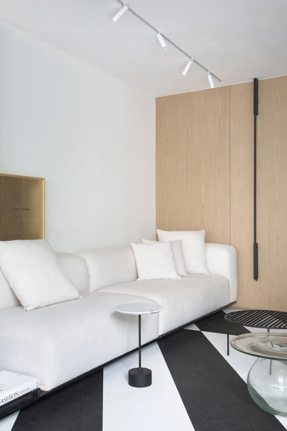 Living minimalista con sofá blanco y panel madera natural — proyecto MN House, por Studio Ro-ca