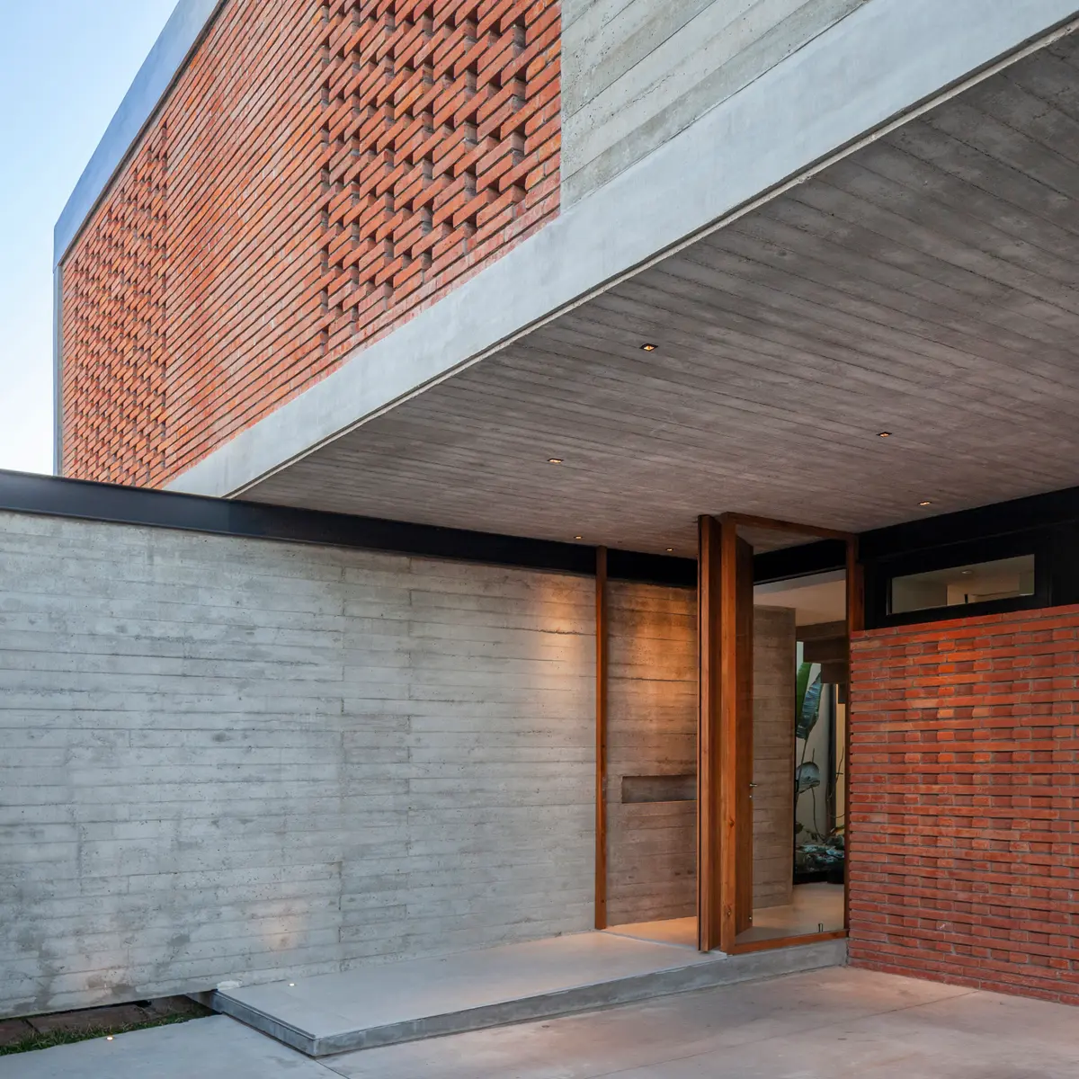 fachada moderna com contraste de concreto e tijolo — projeto CASA BSB, por BUSCETTI & DI BERNARDO arquitectas, em Gonnet