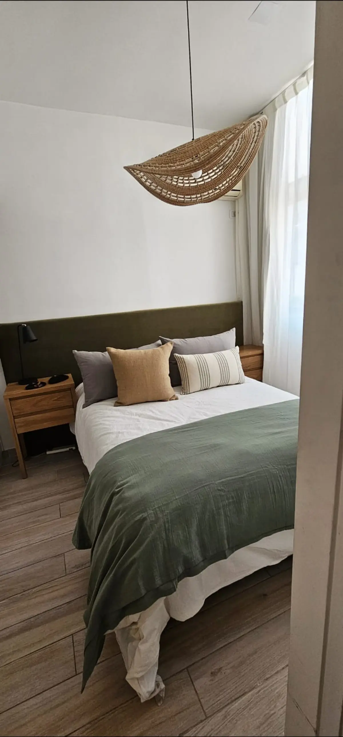 Quarto com luminária pendente de vime e manta verde — projeto Callao, por Claraboia, em Recoleta