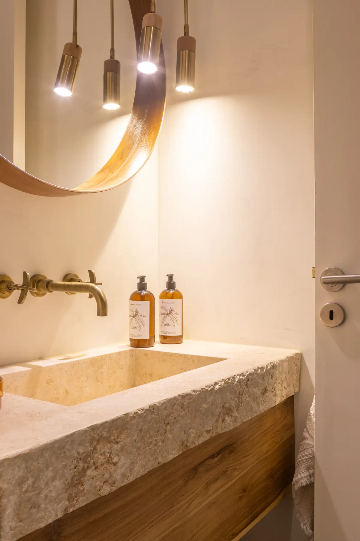 Baño rústico moderno con bacha de piedra y espejo curvo de madera — proyecto CASA OrAz, por Alfredo Orfila arquitectura, en San Isidro