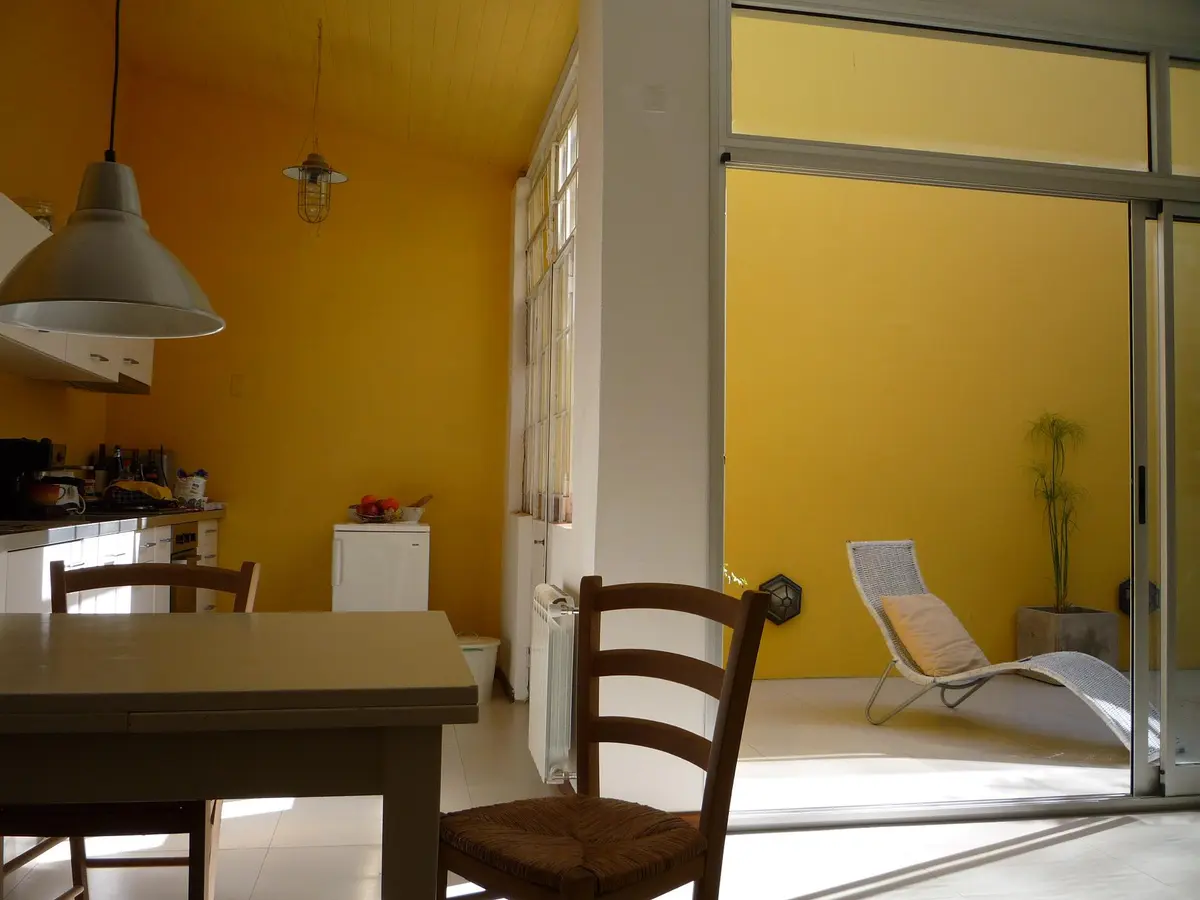 Cocina y comedor moderno con paredes amarillas y mucha luz — proyecto Casa Thomas, por Estudio Dante Fiorenza, en La Plata