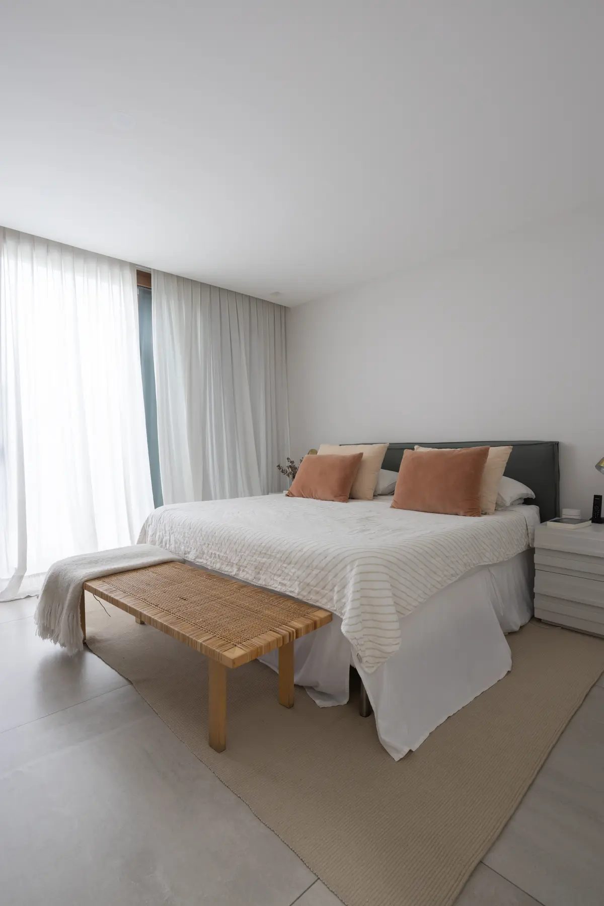 Dormitorio moderno con cortinas blancas y banco de ratán — proyecto CASA OrAz, por Alfredo Orfila arquitectura, en San Isidro