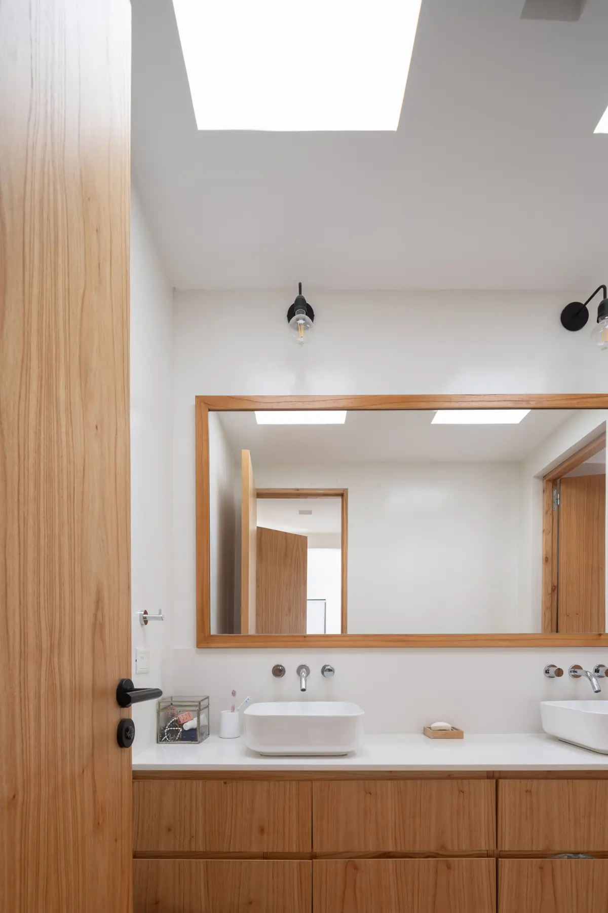 Banheiro moderno com gabinete de madeira e duas cubas de apoio — projeto CASA RuZa, por Alfredo Orfila arquitectura, em Benavidez