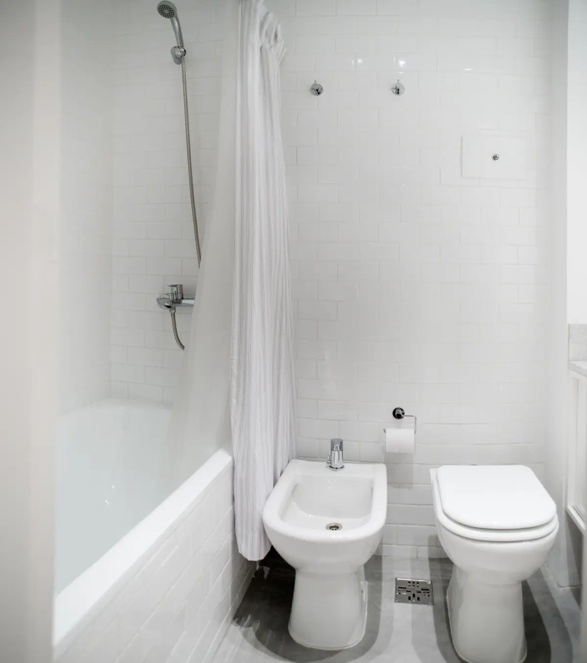 Baño moderno blanco con bañera, bidet e inodoro — proyecto República de la India, por Estudio Basa, en Palermo
