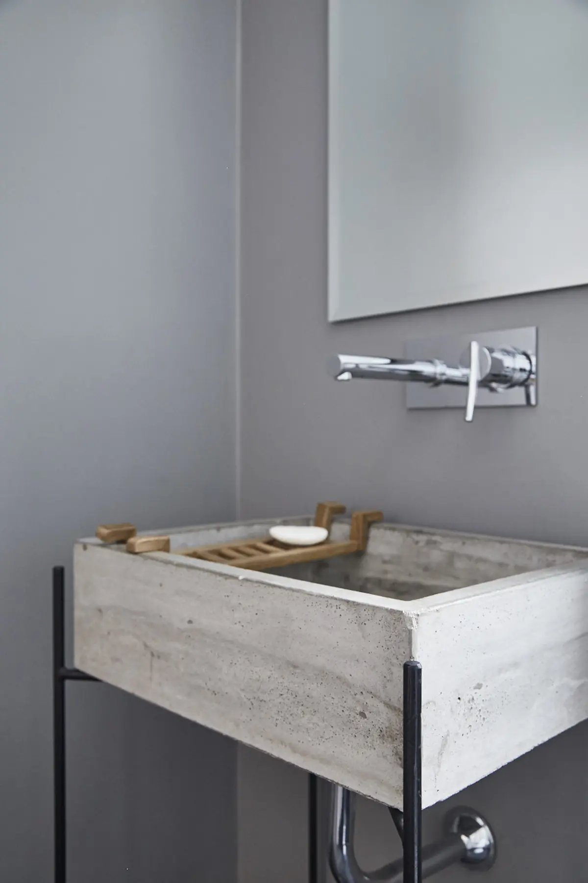 Baño moderno con bacha de cemento, grifería de pared y espejo — proyecto UGARTECHE, por Estudio Trama, en Palermo
