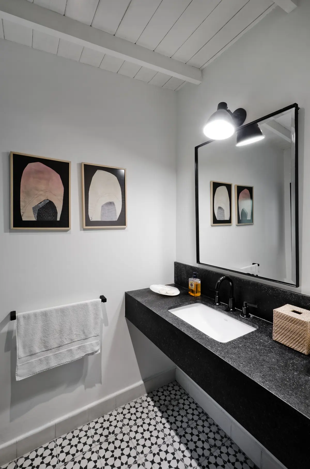 Baño moderno con vanitory de piedra negra, bacha blanca y espejo grande — proyecto Casa BA, por Estudio Dado, en Pilar