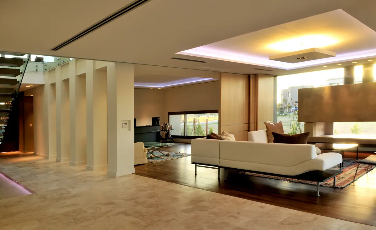 living moderno con sofá modular y iluminación indirecta — proyecto Moderna Seducción, por Apaarquitectura, en Tigre