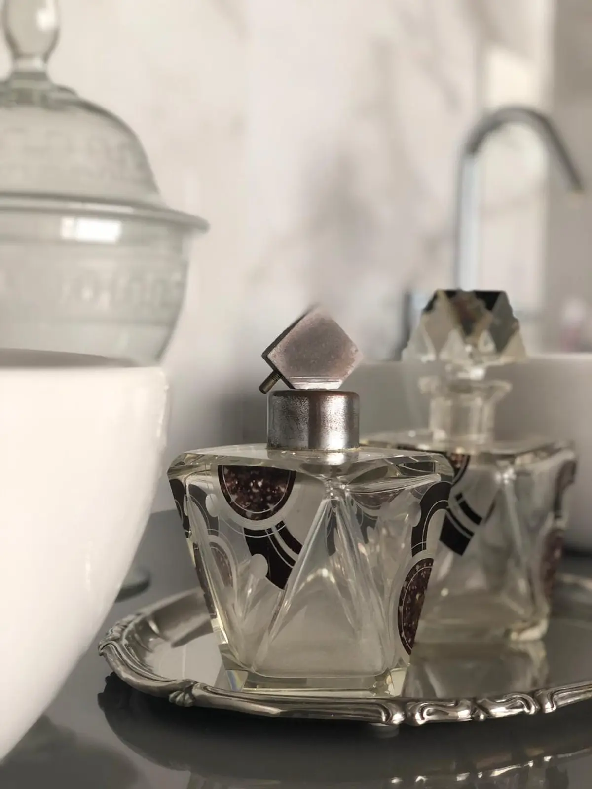 dos botellas de perfume de vidrio tallado sobre bandeja plateada — proyecto Casa Nordelta, por Etude Interiorismo, en Nordelta