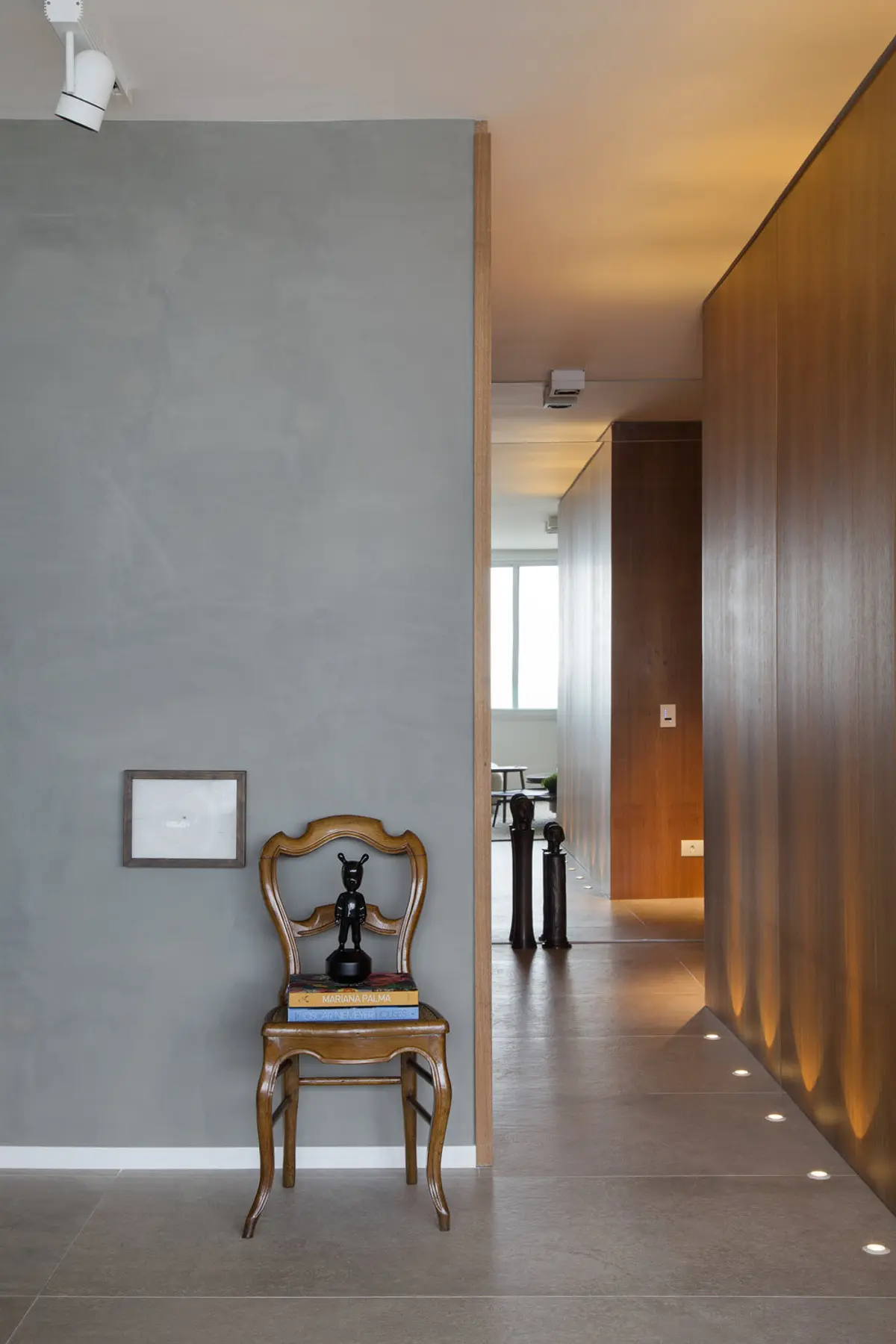 Pasillo moderno con pared gris, silla antigua y madera clara — proyecto PL House, por Studio Ro-ca