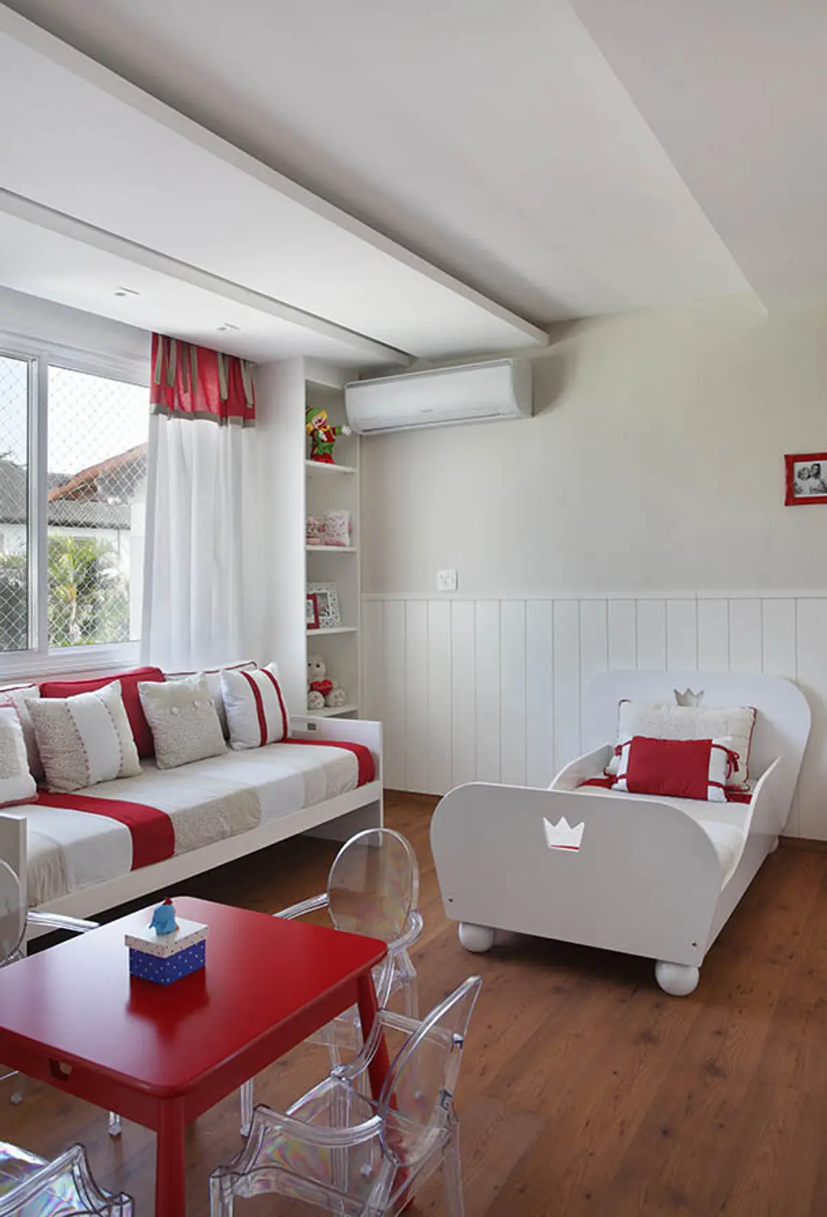 Dormitorio infantil blanco y rojo con cama y sillón frente a ventanal — proyecto Casa Barra ED, por Amanda Miranda