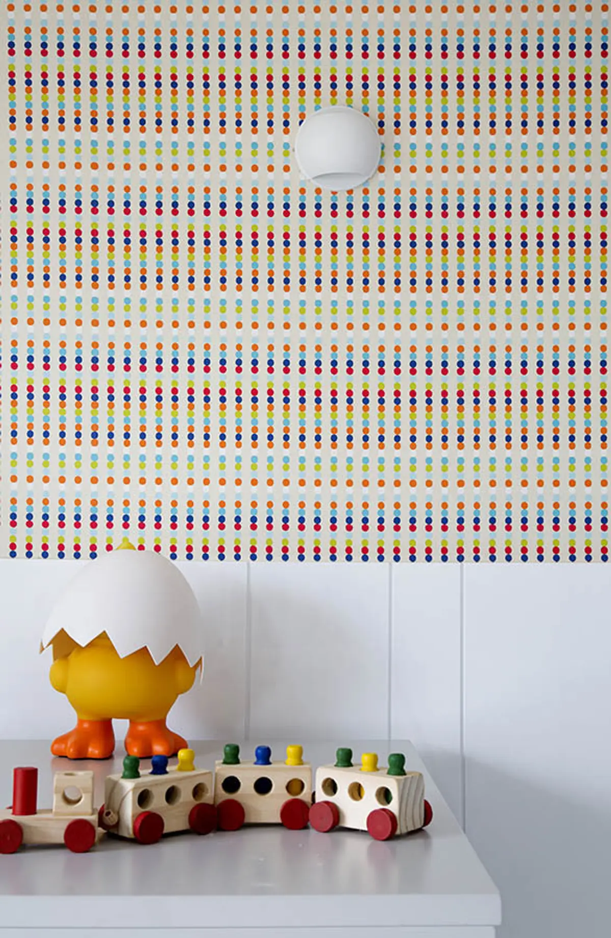 Juguete educativo de madera con piezas coloridas sobre pared de puntos — proyecto Casa Blue House, por Amanda Miranda