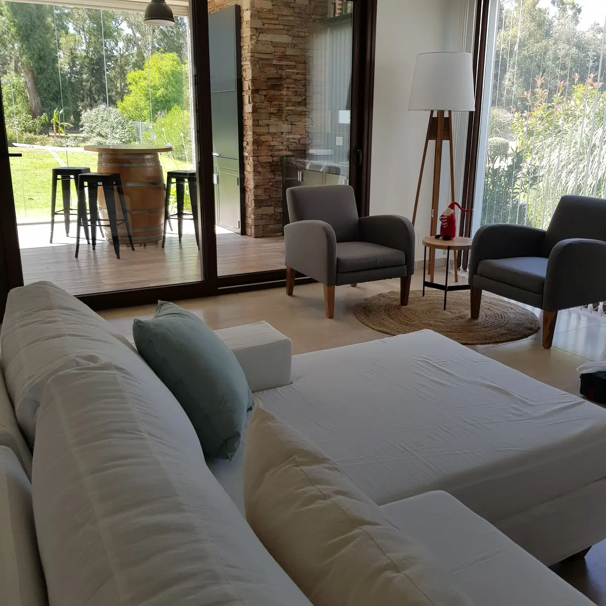 Living comedor con amplios ventanales y ladrillo expuesto — proyecto Casa FA, por Vicky Hurrell, en Mar del Plata