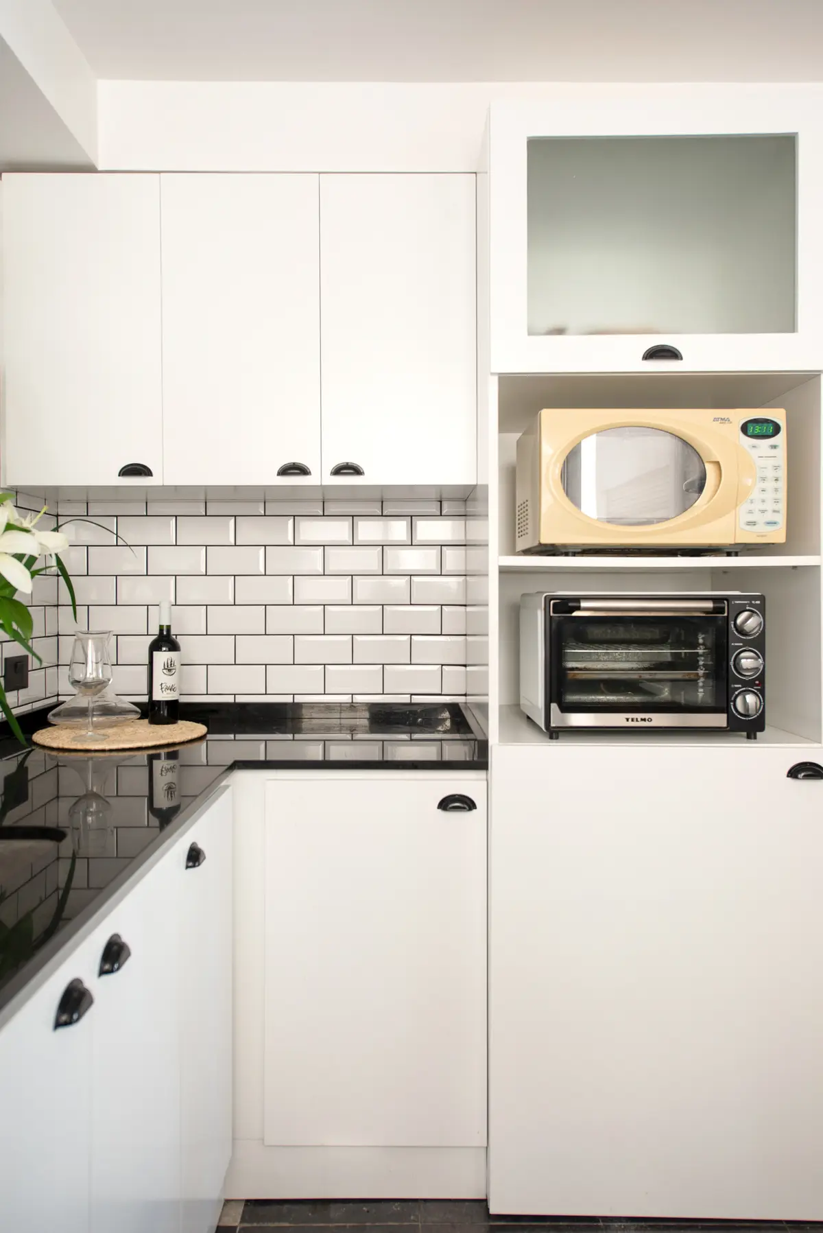 Cozinha moderna e escandinava com armários brancos e bancadas pretas — projeto OBRA SALGUERO, por G+M Arquitectura, em CABA