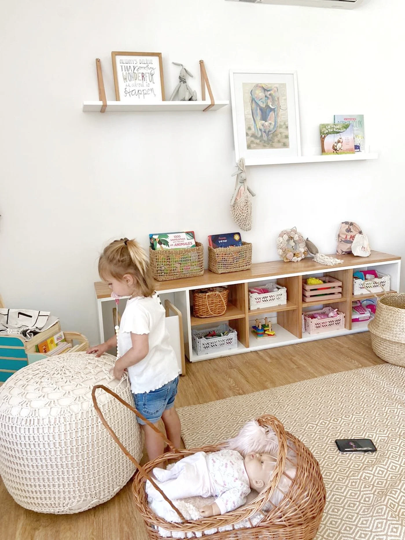 Dormitorio infantil escandinavo con estanterías modulares y canasto de mimbre