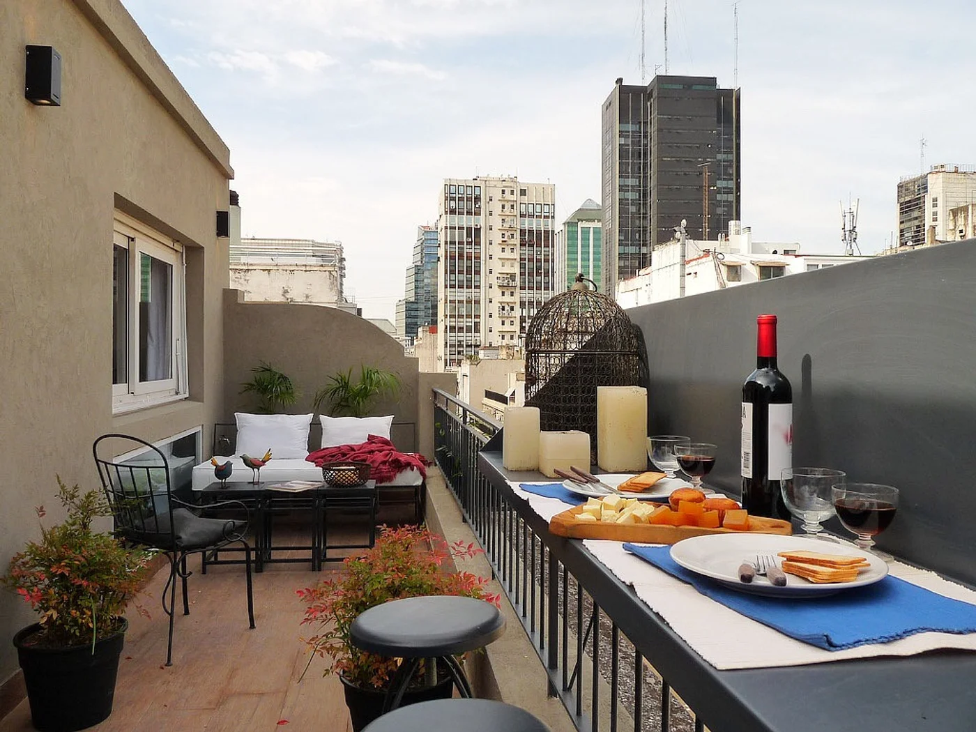 Terraza urbana con vista a rascacielos, mesa y sillones de comedor