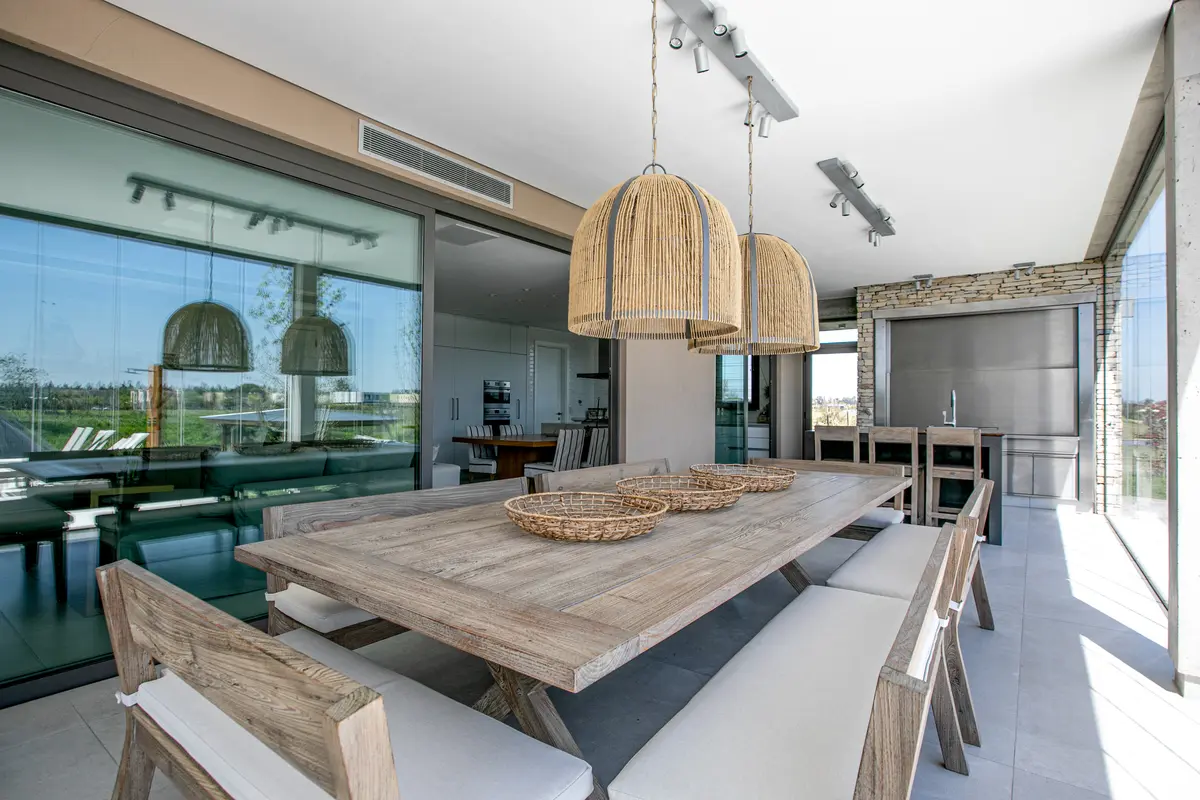 Comedor contemporáneo con isla de madera, lámparas de mimbre y grandes ventanales — proyecto ESTUDIO FILCMAN GURFINKIEL , por uchimayfotos