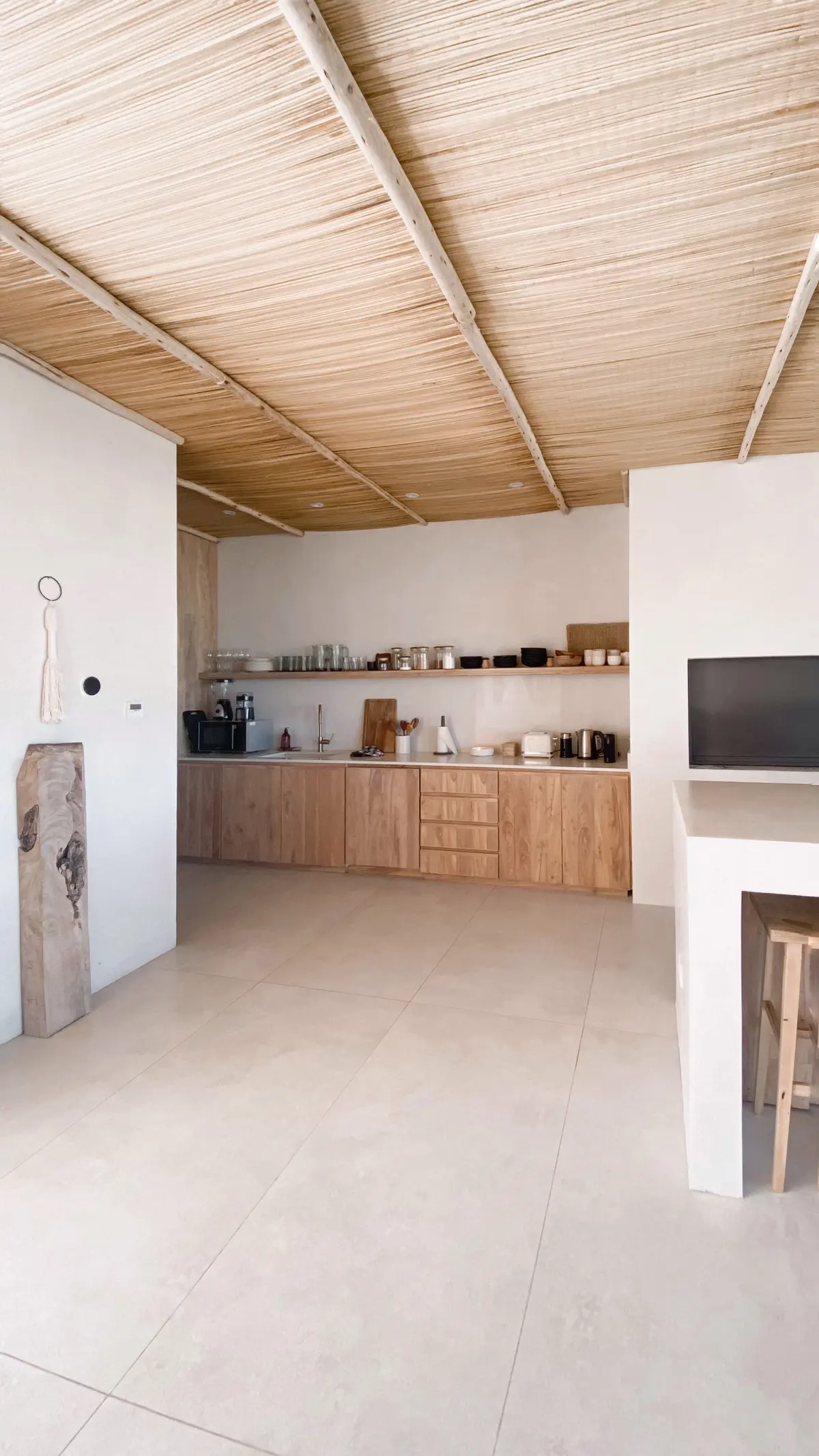 Cozinha minimalista com teto de palha e móveis de madeira natural — projeto El Refugio, por Grupo Pauta Arquitectura, em Pinamar