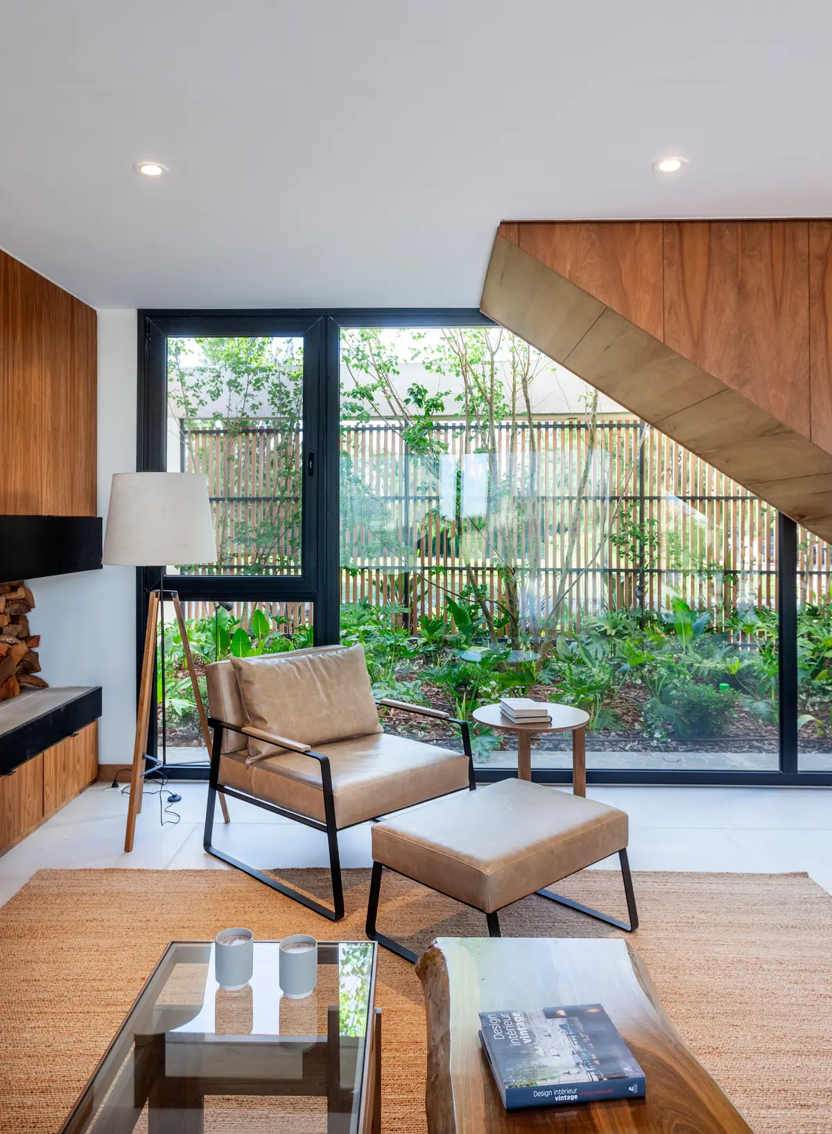 Sala de estar moderna com escada de madeira e jardim interno — projeto Casa Tom, por LSA., em Belén de Escobar
