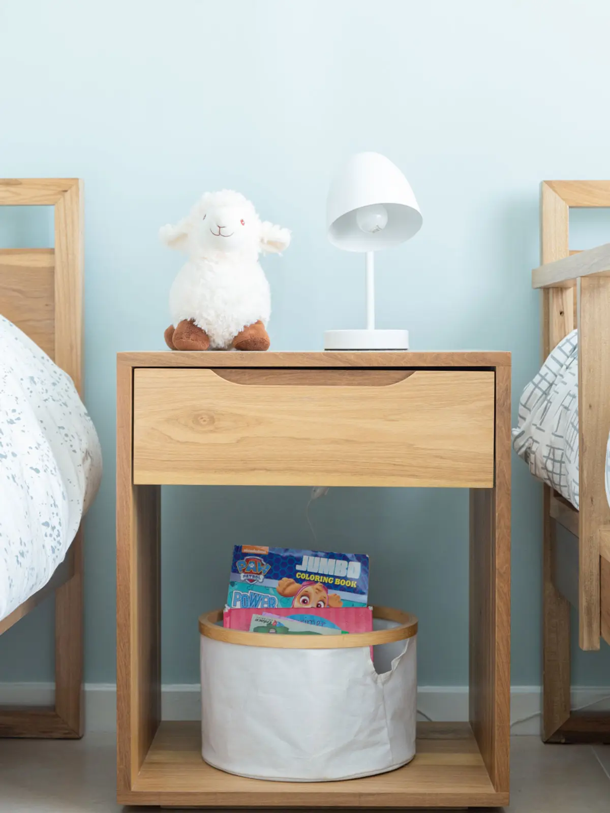 Quarto escandinavo com mesa de cabeceira de madeira e bicho de pelúcia — projeto Proyecto La Horqueta, por Olivia D