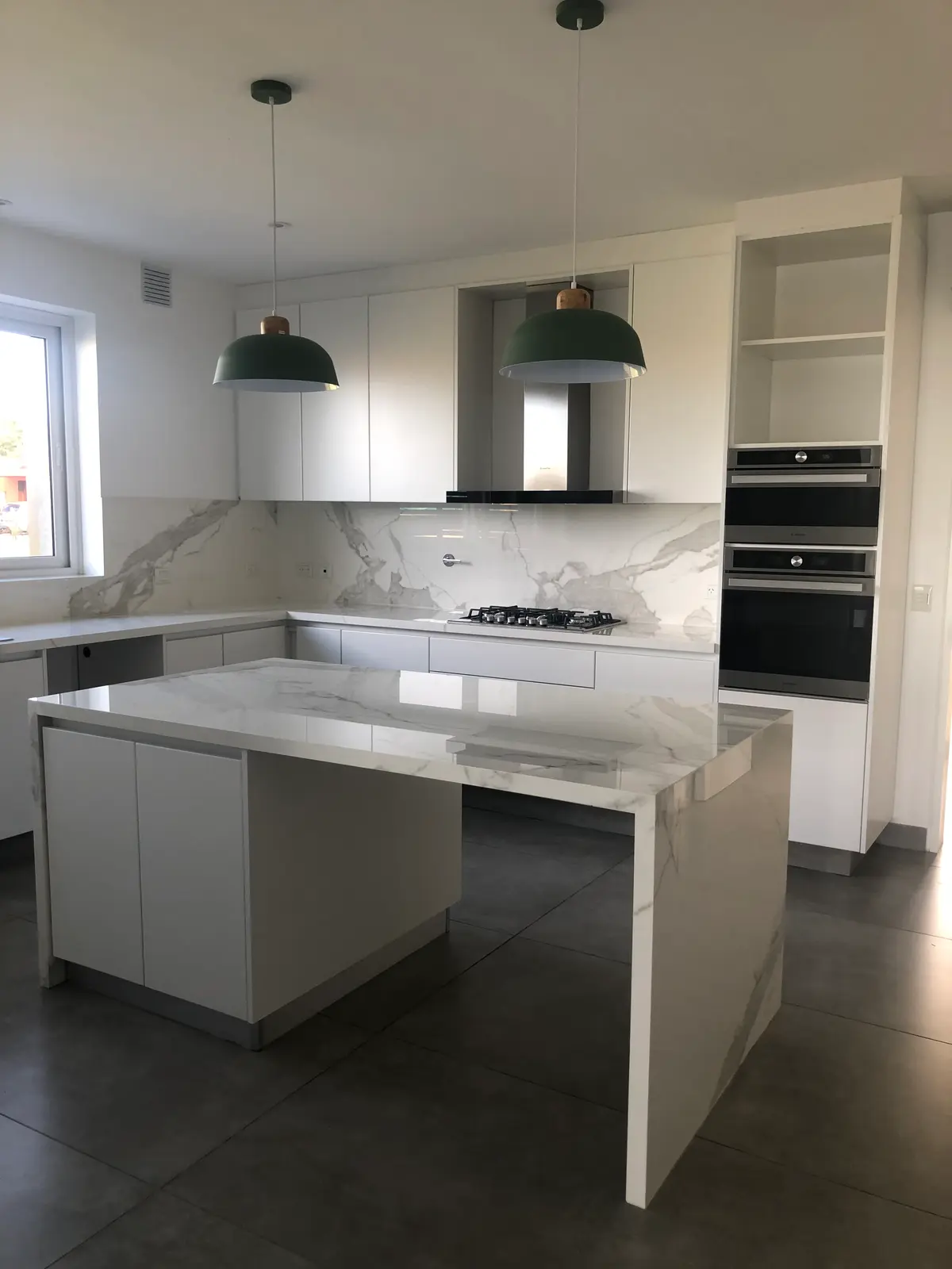 Cozinha moderna com ilha, bancada cascata e luminárias verdes — projeto SAN MATIAS II, por Fb Arqs, em Belén de Escobar