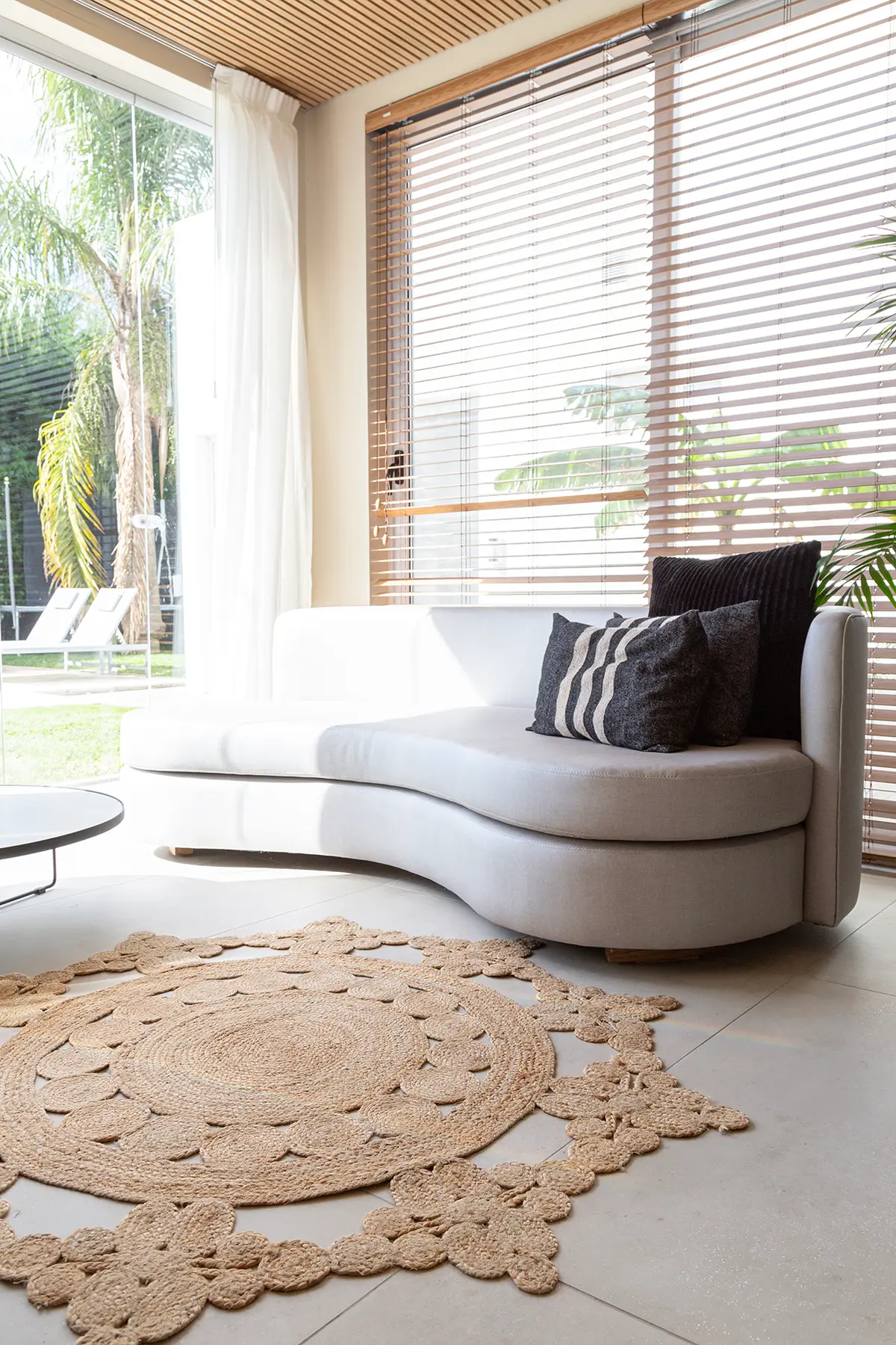 Sala de estar moderna con sofá curvo blanco y alfombra de yute — proyecto Proyecto Gaby P. , por LINEA NETA diseño interior , en Canning