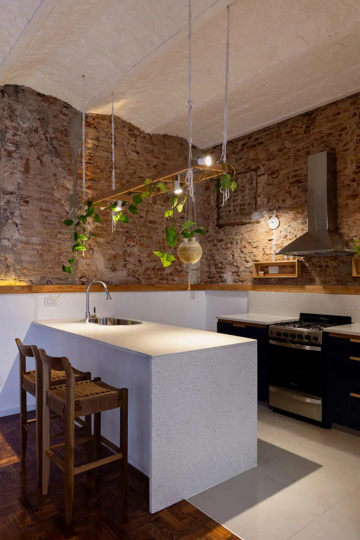 Cozinha industrial moderna com ilha de pedra e tijolo aparente — projeto PH Baires, por Ramiro Sosa Fotografia