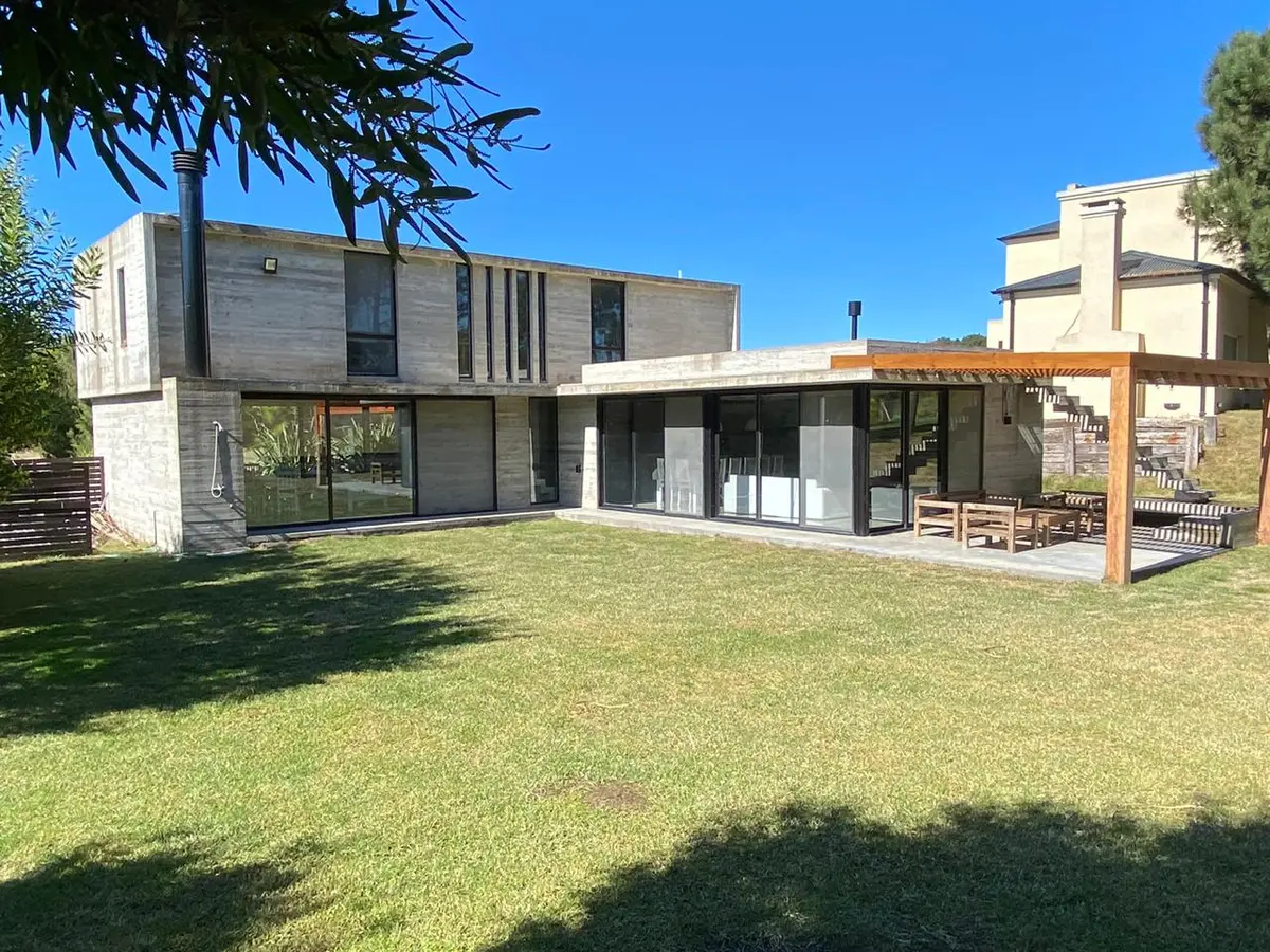 Fachada moderna de concreto com amplas janelas e pátio — projeto Casa R2, por Guerrero Arquitectos, em Pinamar