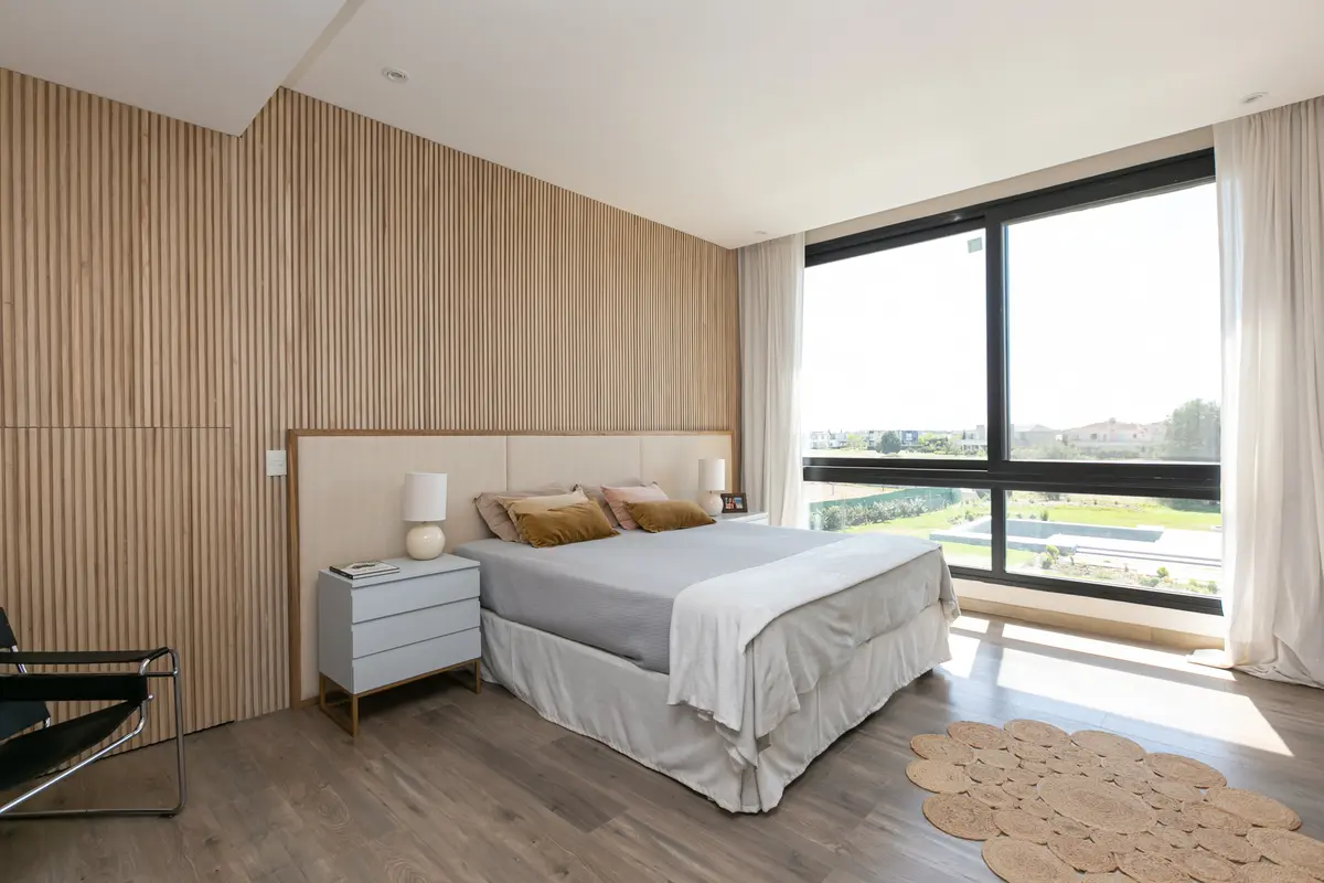 Quarto moderno com parede ripada e janelas amplas — projeto La volanta 152, por ATO Arquitectos
