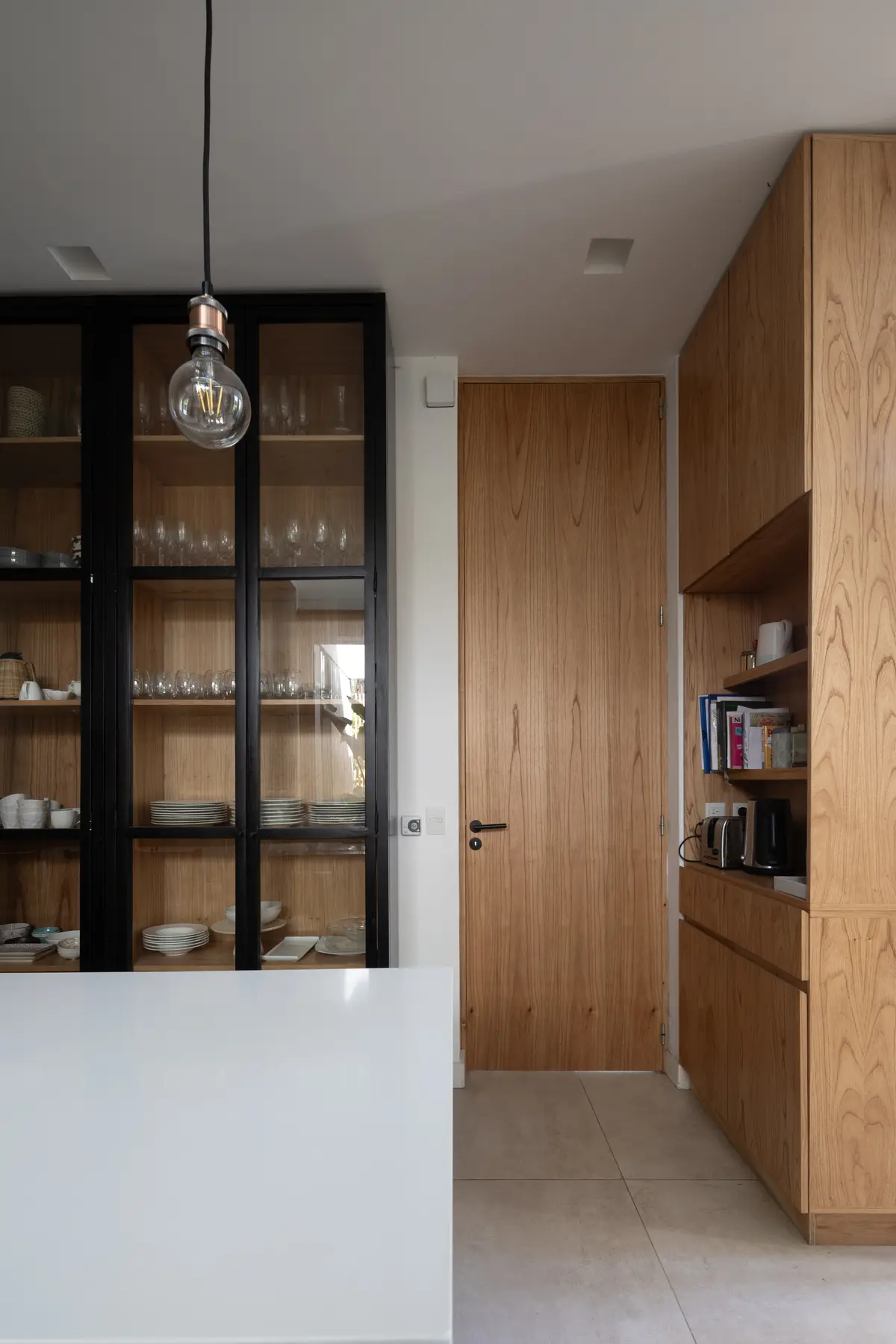Cocina moderna con isla blanca, alacenas de madera y puerta de madera — proyecto CASA RuZa, por Alfredo Orfila arquitectura, en Benavidez