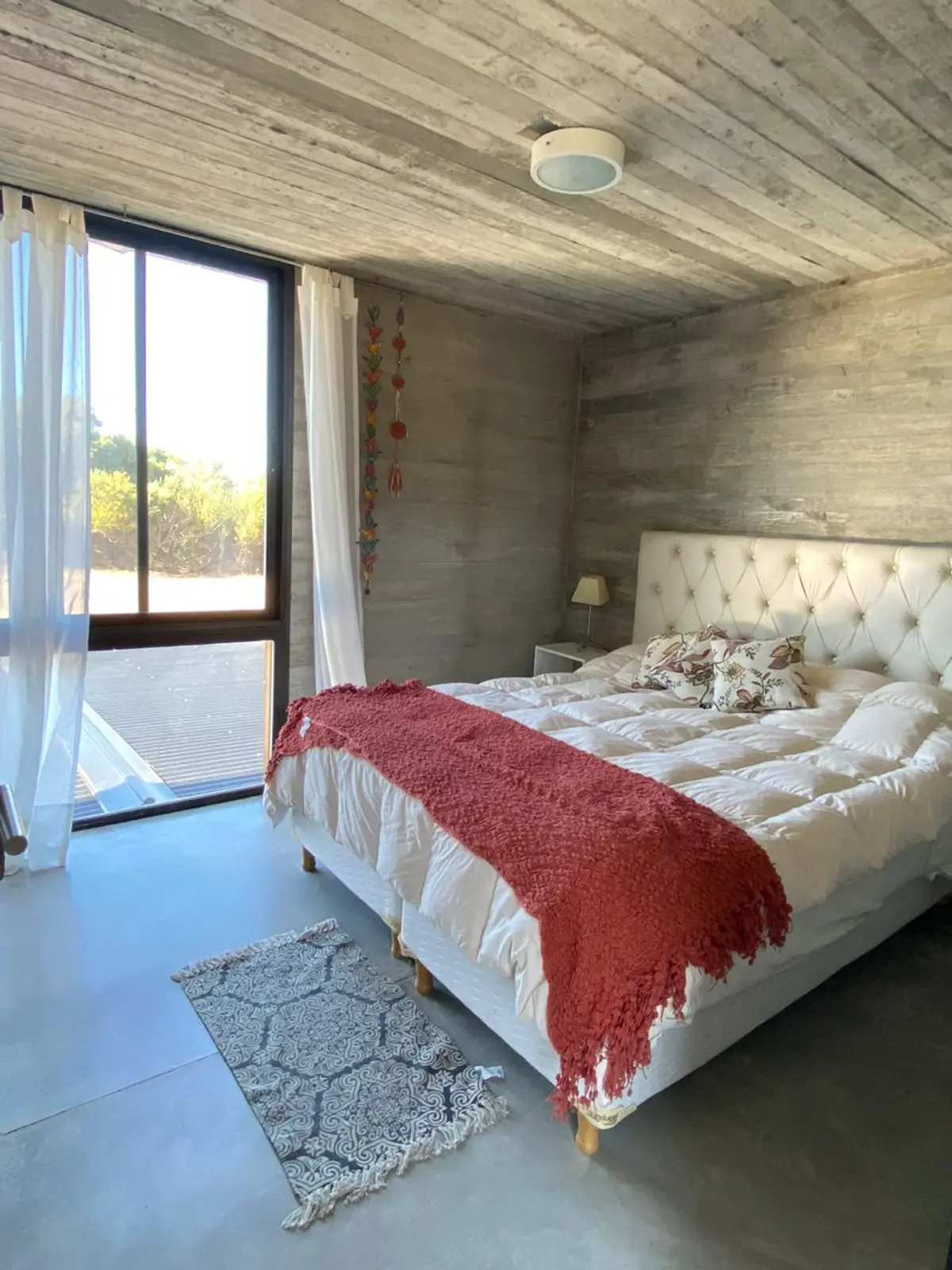 Quarto brutalista com teto de concreto aparente e cama king-size — projeto Casa R2, por Guerrero Arquitectos, em Pinamar