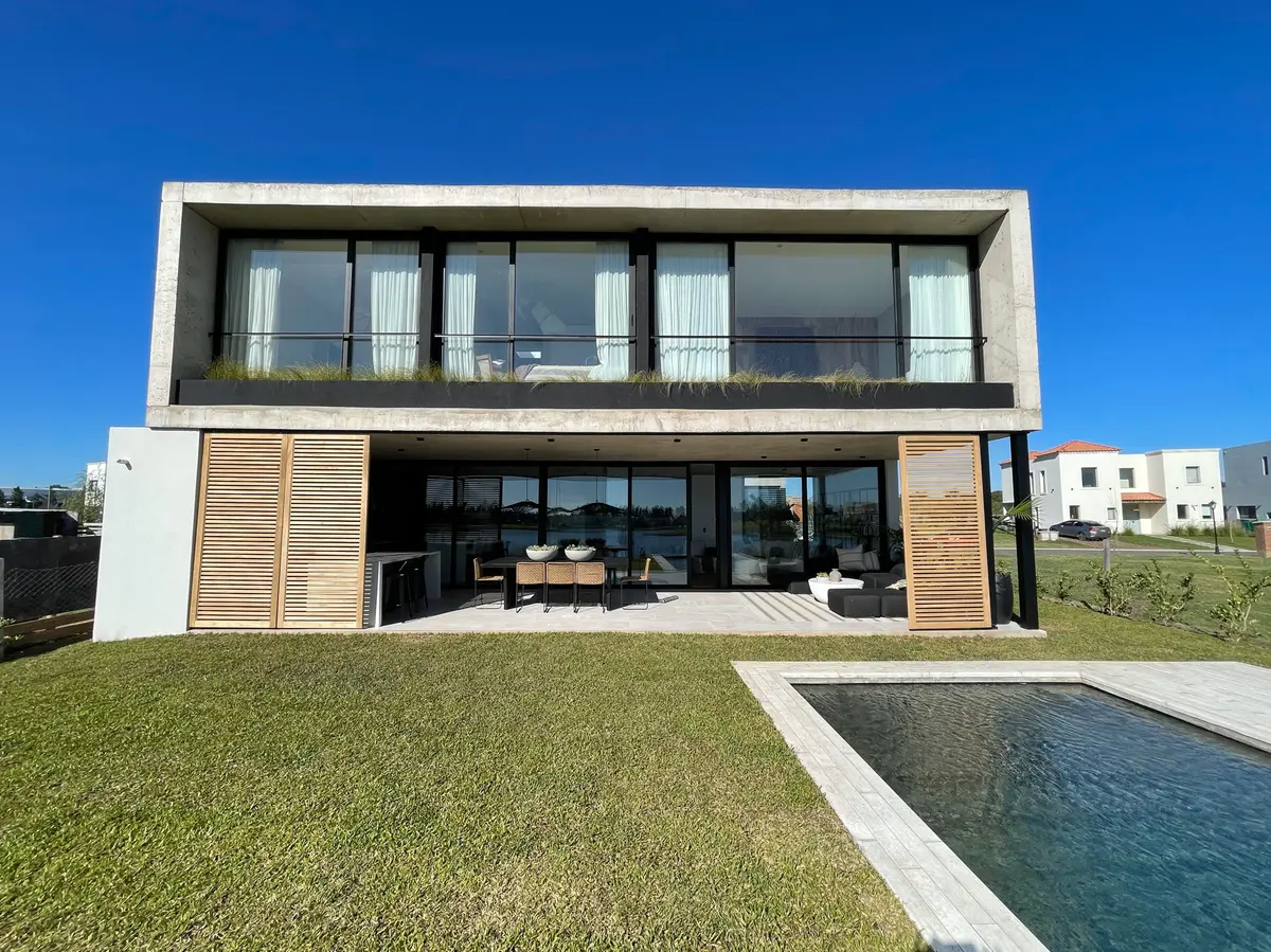 Casa moderna com fachada de concreto e grandes janelas — projeto El Secreto, por Grupo Pauta Arquitectura, em Tigre