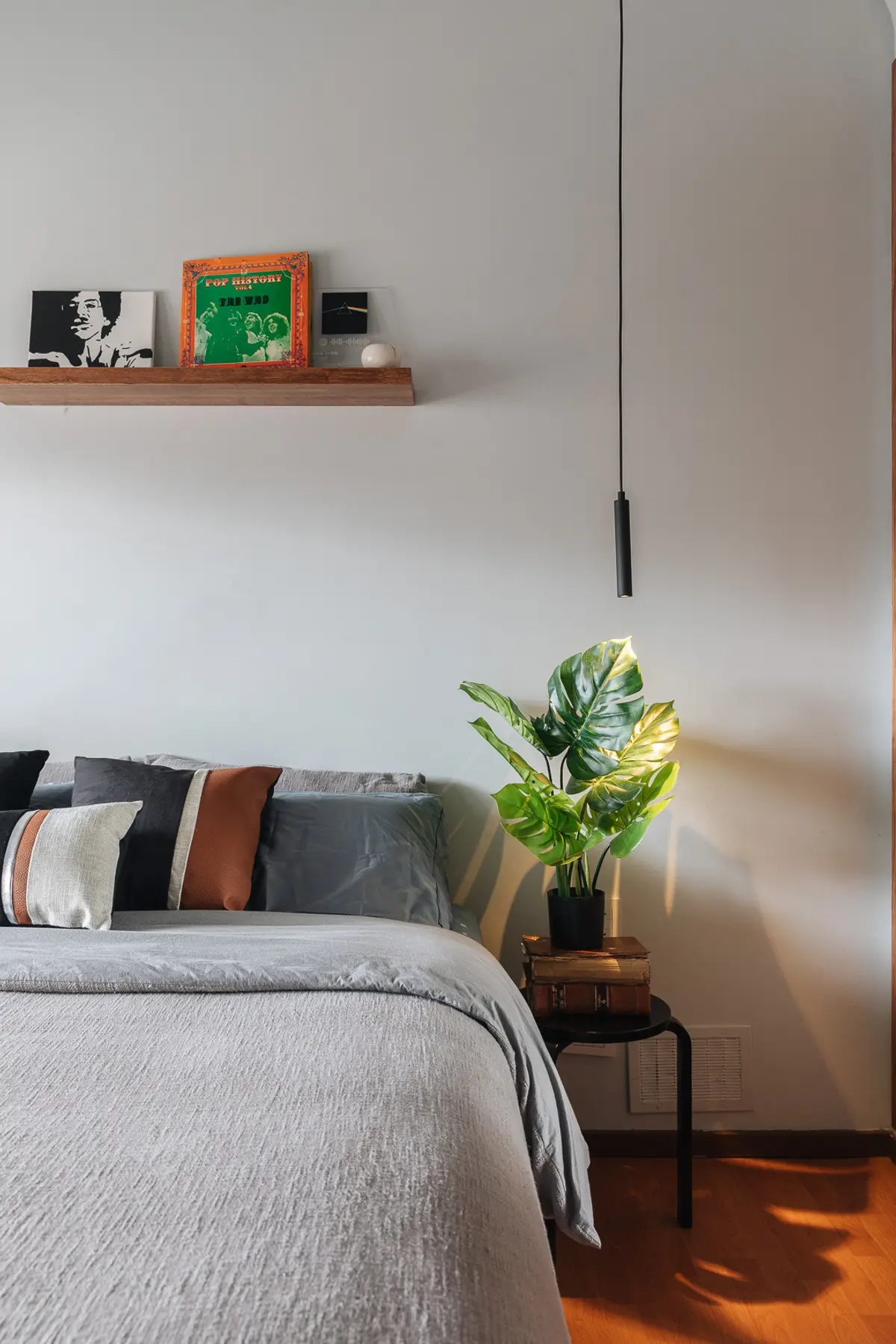 Quarto moderno com cama cinza, planta e luminária pendente — projeto Olazabal 1150, por KUPERDESIGN CONSTRUCCIONES SRL, em Belgrano