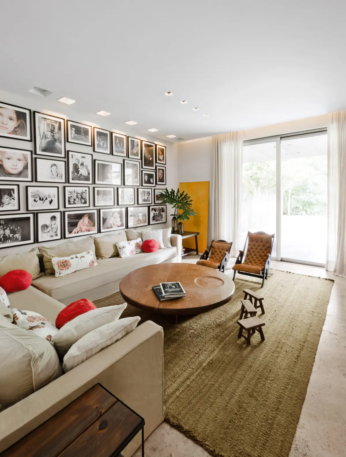 Sala de estar moderna con pared de cuadros y sofá modular — proyecto Casa H, por Estudio Dado, en Belgrano