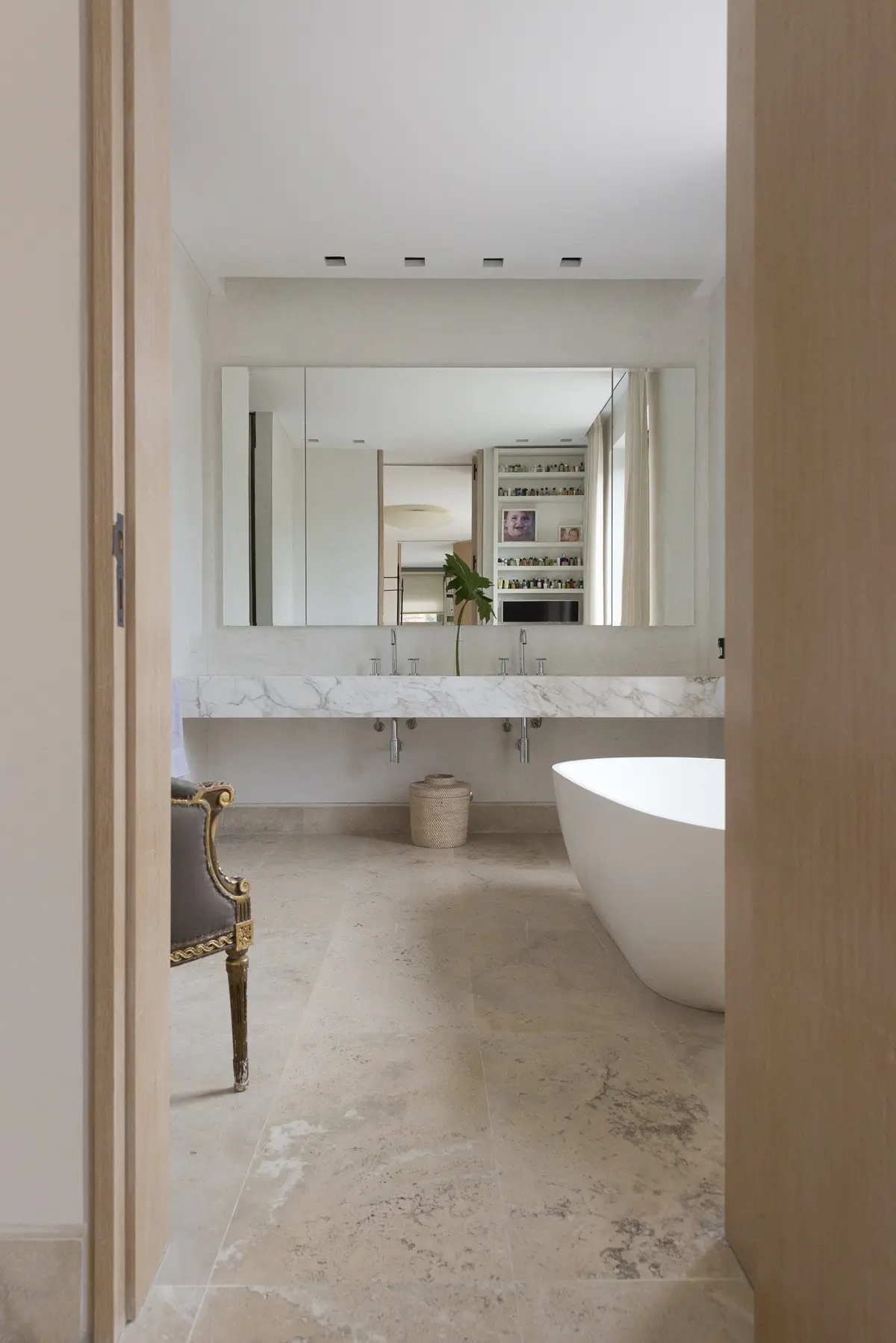 Baño moderno minimalista con bañera exenta y suelo de piedra — proyecto Casa H, por Estudio Dado, en Belgrano