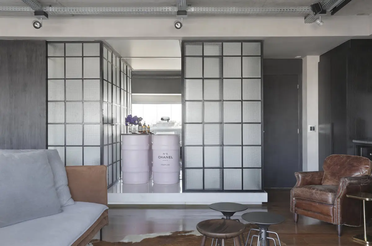 Living contemporáneo con divisor vidrio, sofás cuero, piso madera — proyecto RA Loft, por Studio Ro-ca