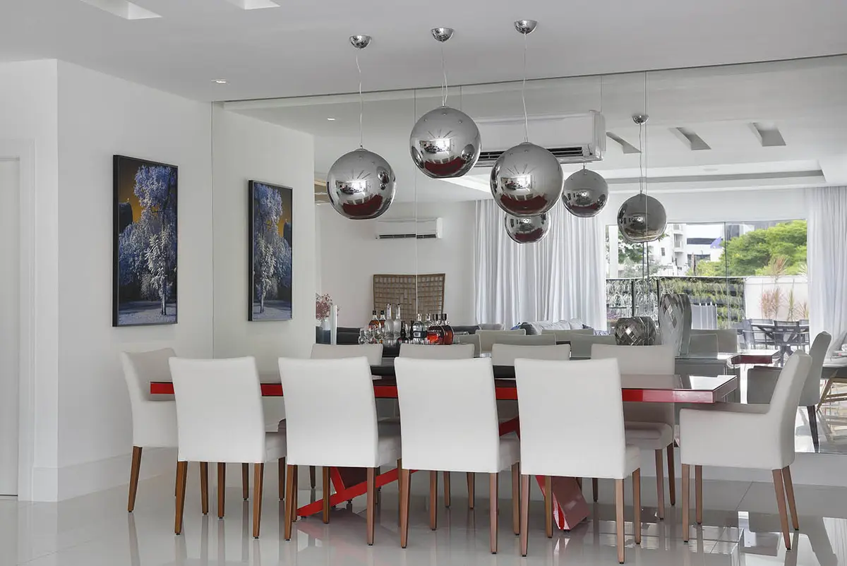 Comedor minimalista con sillas blancas y lámparas colgantes metalizadas — proyecto Casa Blue House, por Amanda Miranda