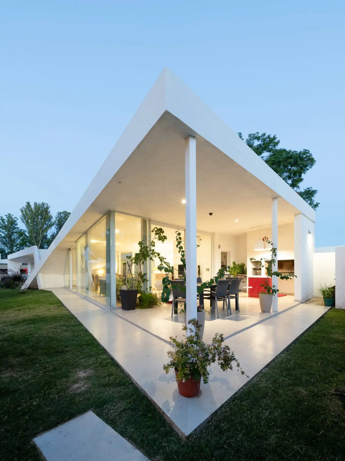 Casa blanca minimalista con techo a dos aguas y galeria acristalada — proyecto Casa X, por Síncresis Arquitectos, en Santina Norte