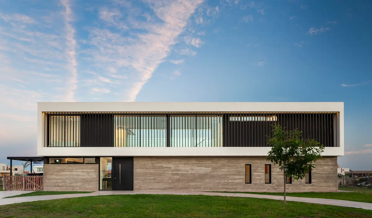 fachada moderna de casa residencial con concreto y amplios ventanales — proyecto SS A7, Pilar, por ZUID PORT, en Pilar