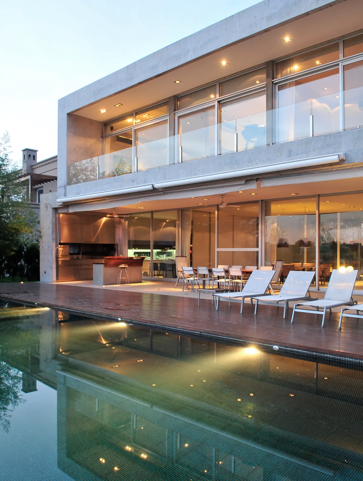 Casa moderna com piscina e espreguiçadeiras brancas — projeto Casa AB, por Santiago Cordeyro Arquitectos, em Nordelta