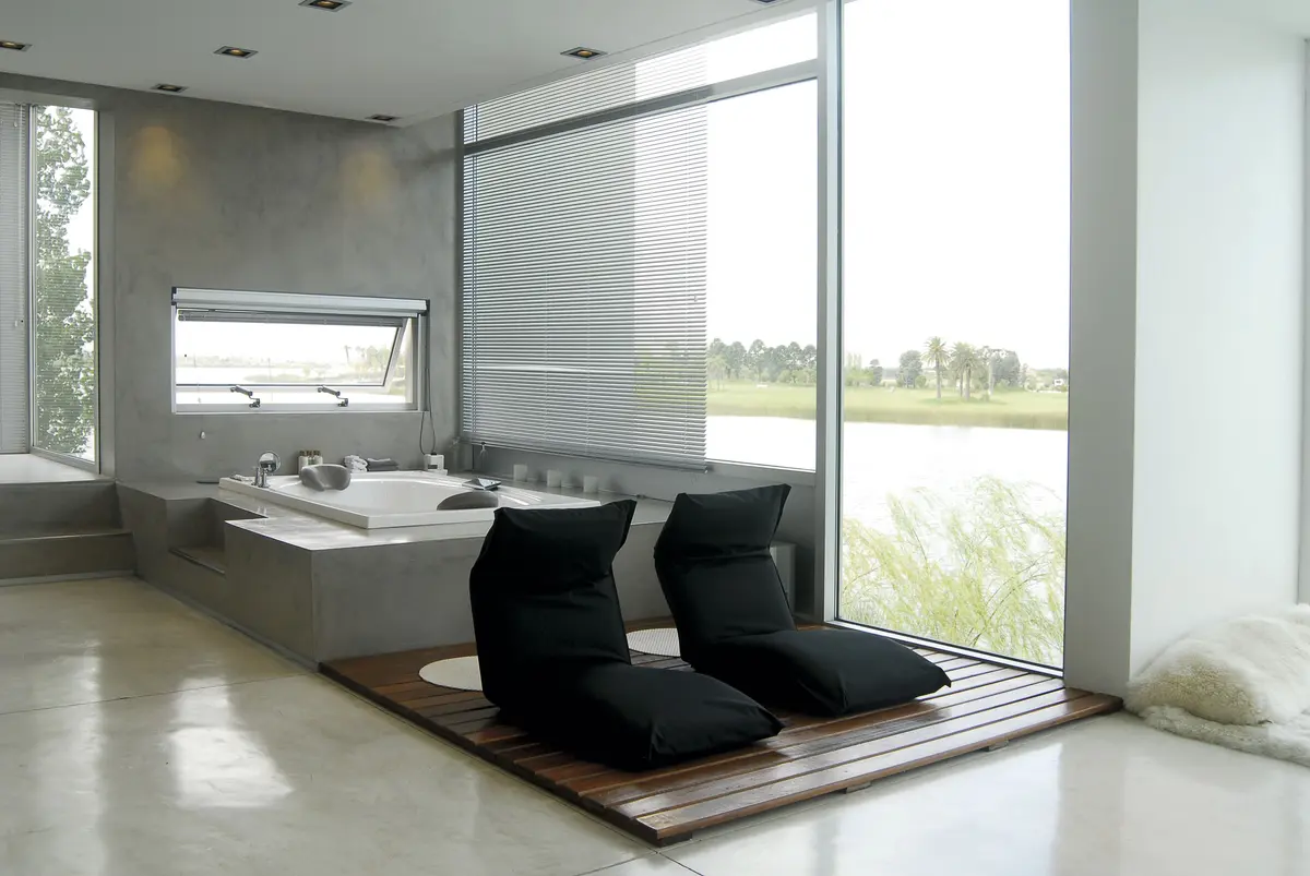 banheiro moderno minimalista com vista para o mar e poltronas — projeto Casa JD, por Santiago Cordeyro Arquitectos, em Tigre
