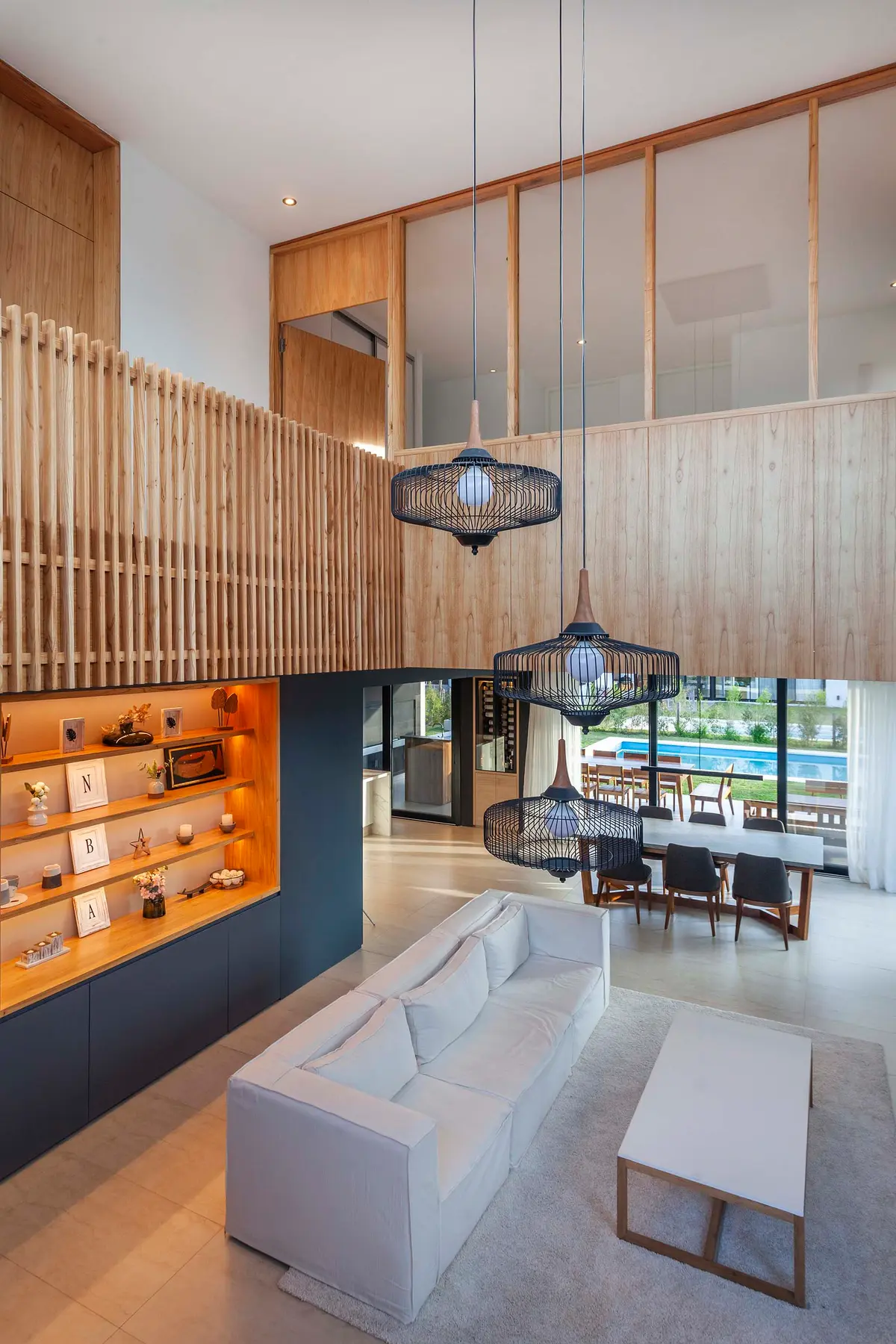 Sala de estar e jantar moderna com pé-direito duplo e madeira — projeto Castaños, por GO arquitectos, em Rincón de Milberg