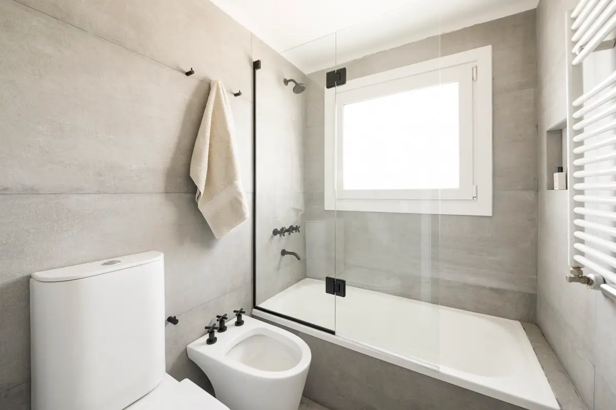 Baño moderno con paredes de microcemento gris y bañera exenta — proyecto Boating Club, por SRMD Arquitectura, en Boating Club