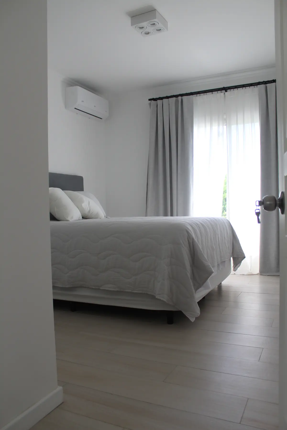 Dormitorio moderno con cama queen y cortinas grises y blancas — proyecto CASA LA LOMADA , por Estudio Grupo 32, en Pilar