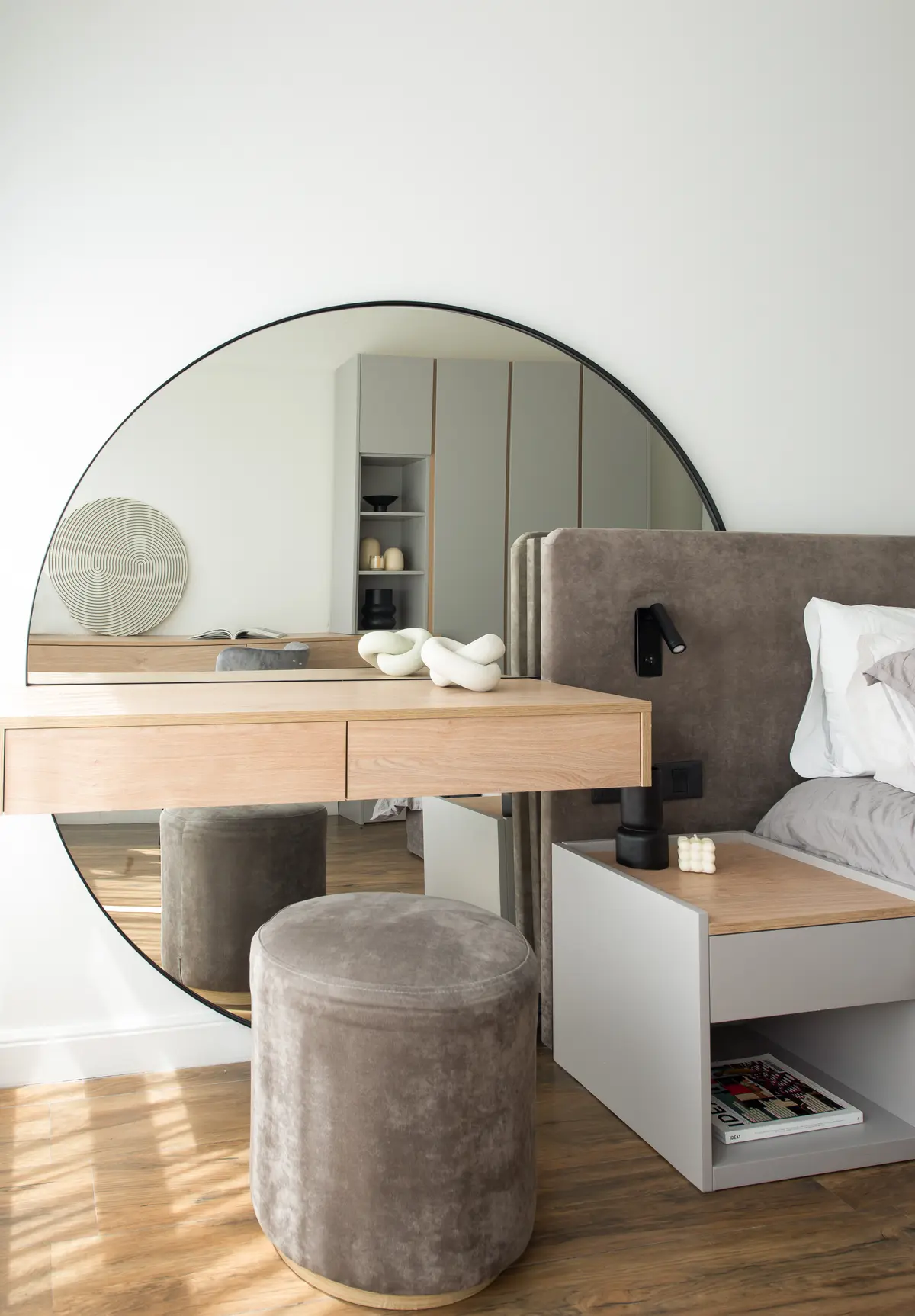 Dormitorio moderno escandinavo con espejo redondo y tocador flotante — proyecto Artilleros Plaza, por C - ESTUDIO, en Buenos Aires