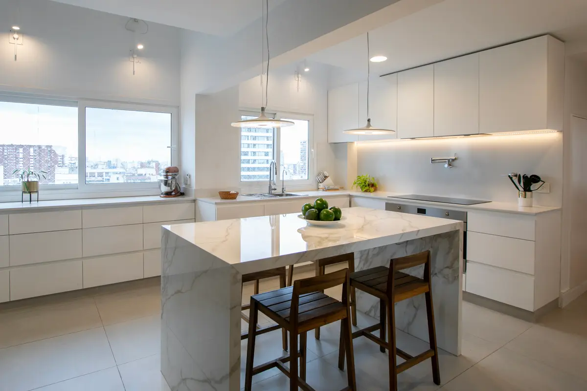 Cocina moderna minimalista con isla de mrmol y vistas urbanas — proyecto Obra Araoz A, por Arq. Lourdes Yarade Saravia, en Buenos Aires