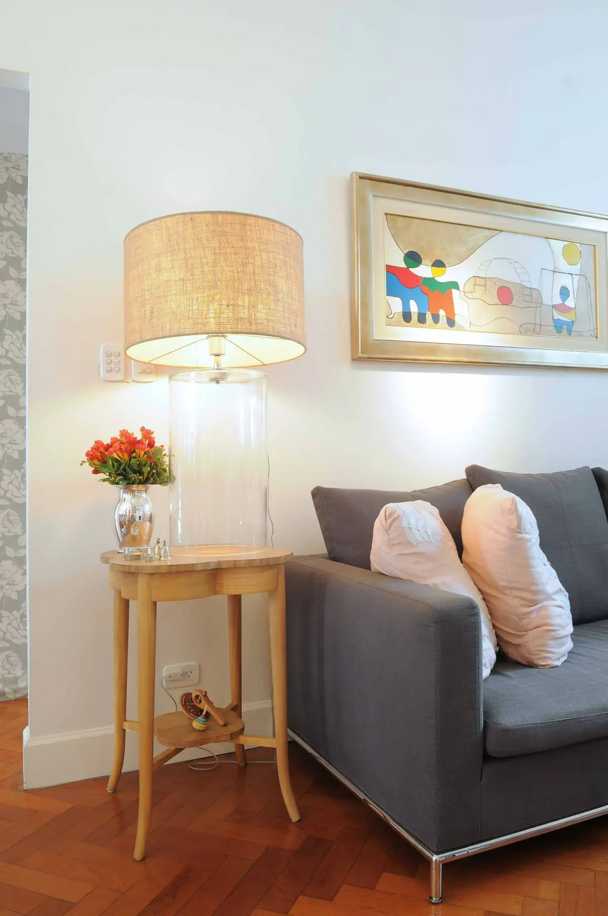 Living moderno con sofá gris, lámpara de lino y mesa lateral madera — proyecto Santa Fe, por Estudio Diez Muzzio, en CABA